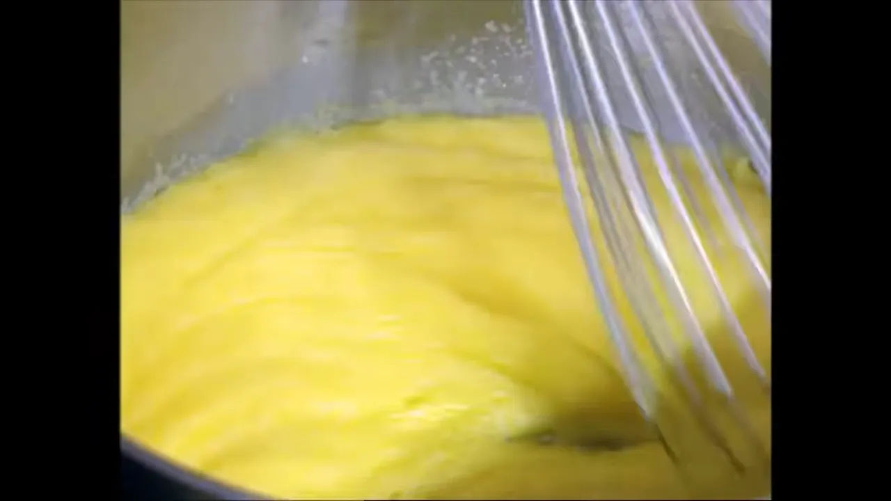 Polenta cooking in a pan while being whisked