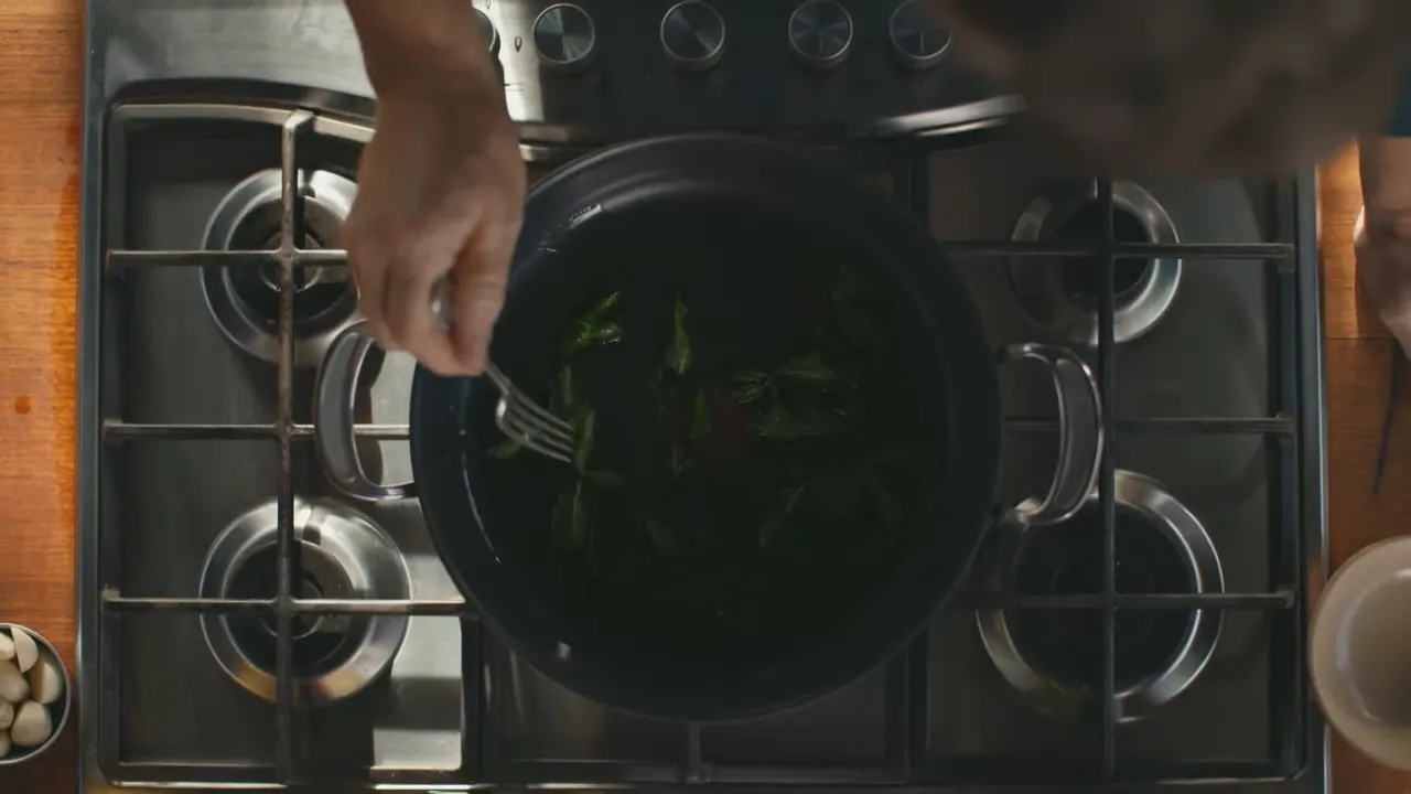 Casserole pan with oil and mint leaves sizzling