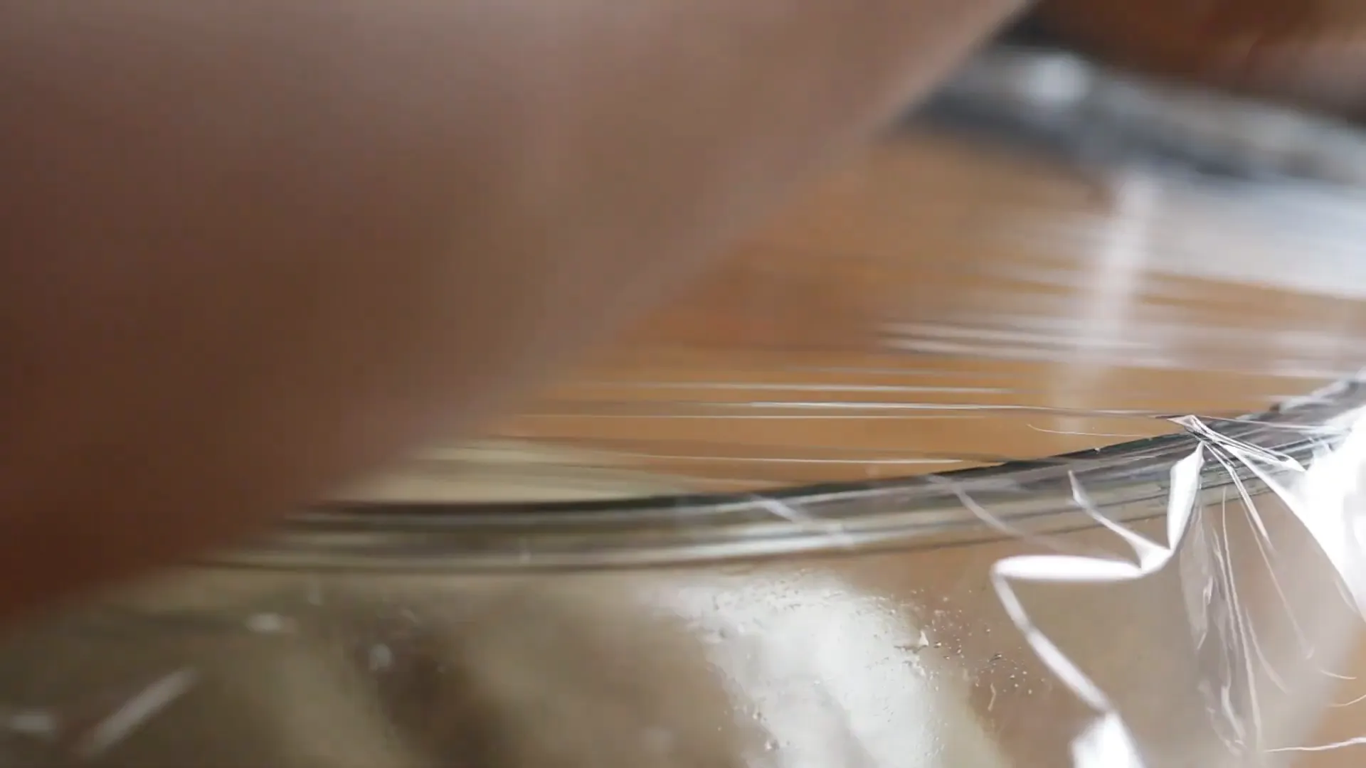 Dough rising in an oiled bowl covered with cling film