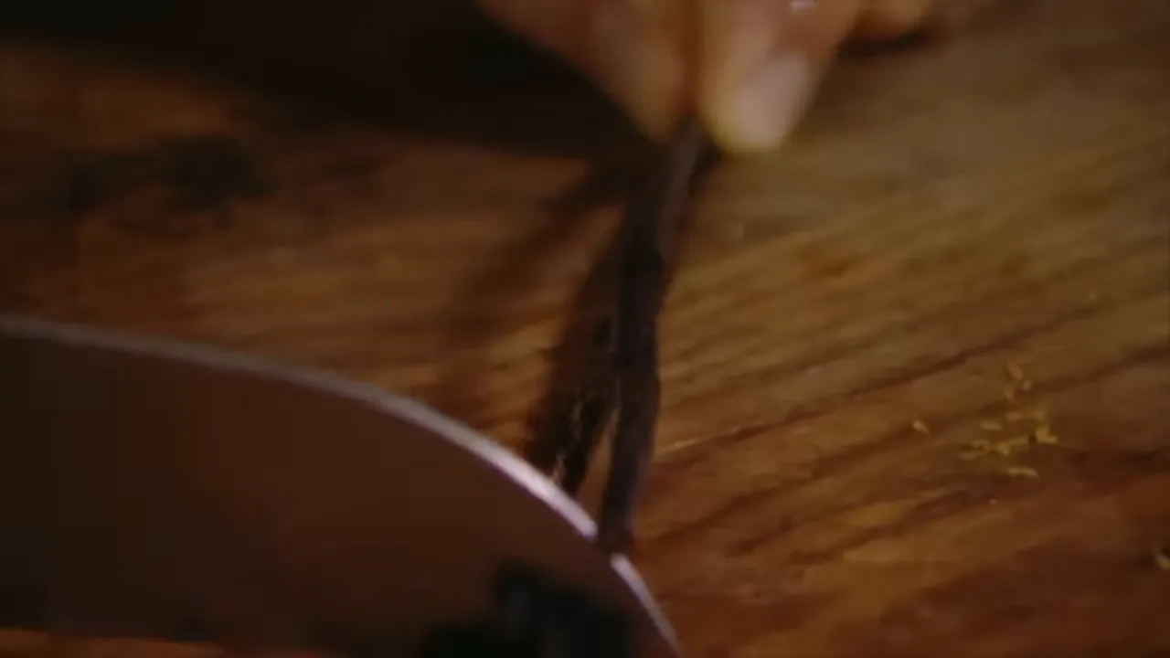 Vanilla pod seeds being scraped into the frosting bowl