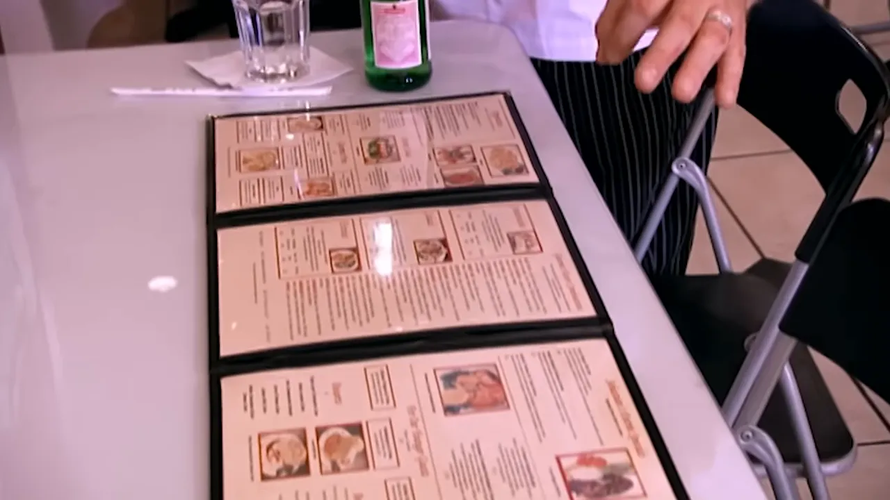 Open multi-page restaurant menu on a table showing many menu options