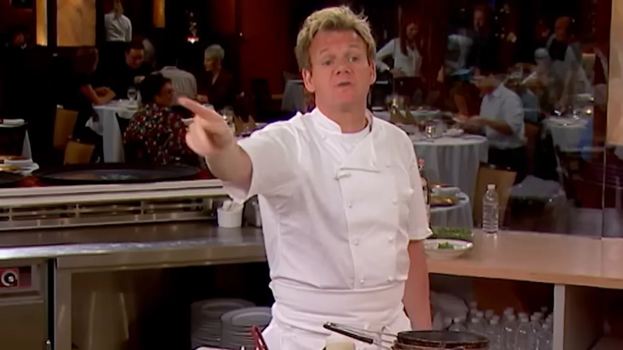 Head chef pointing and addressing the kitchen during service to give instructions.