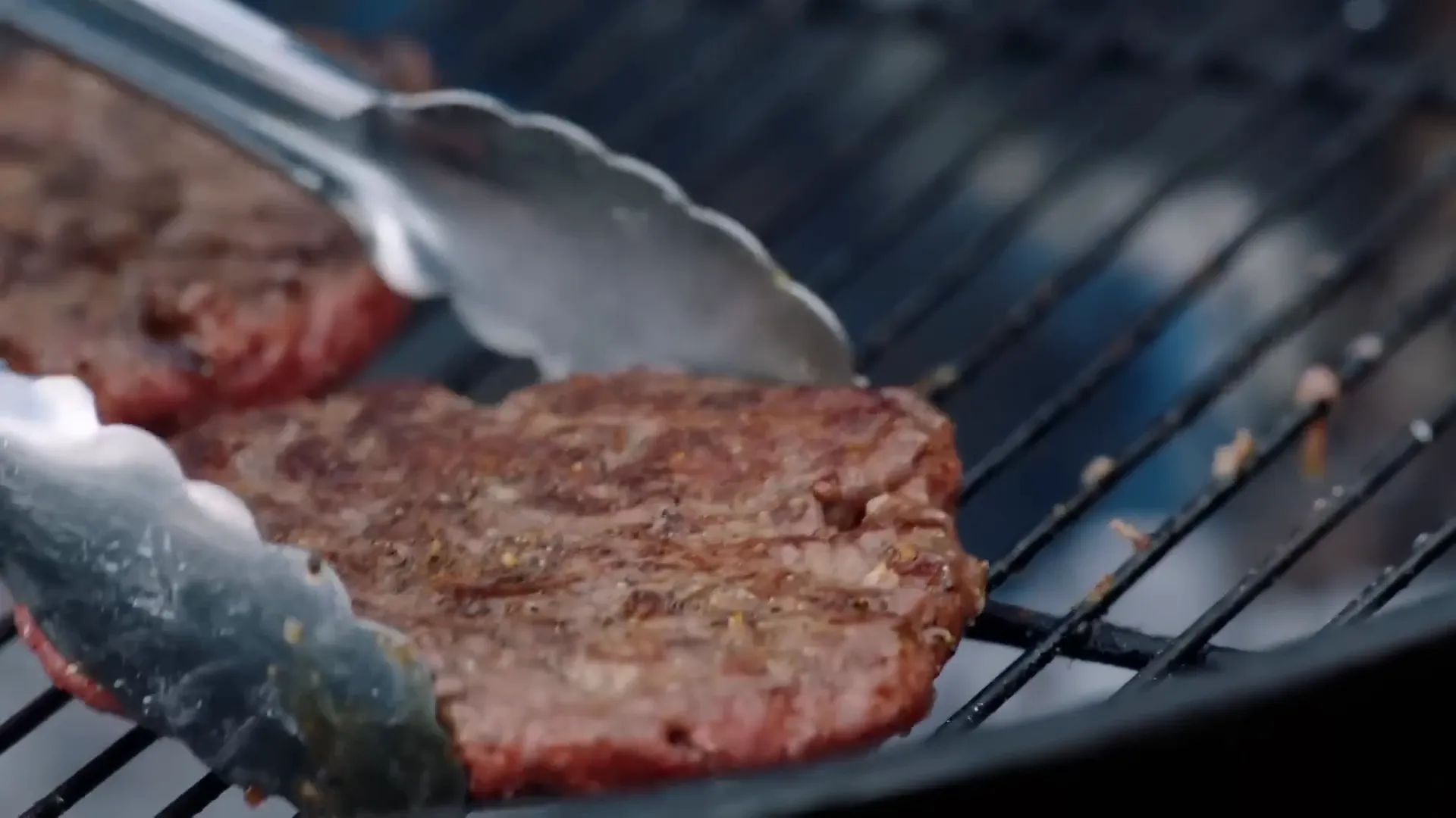 Grilled beef burger patties turning golden on the barbecue
