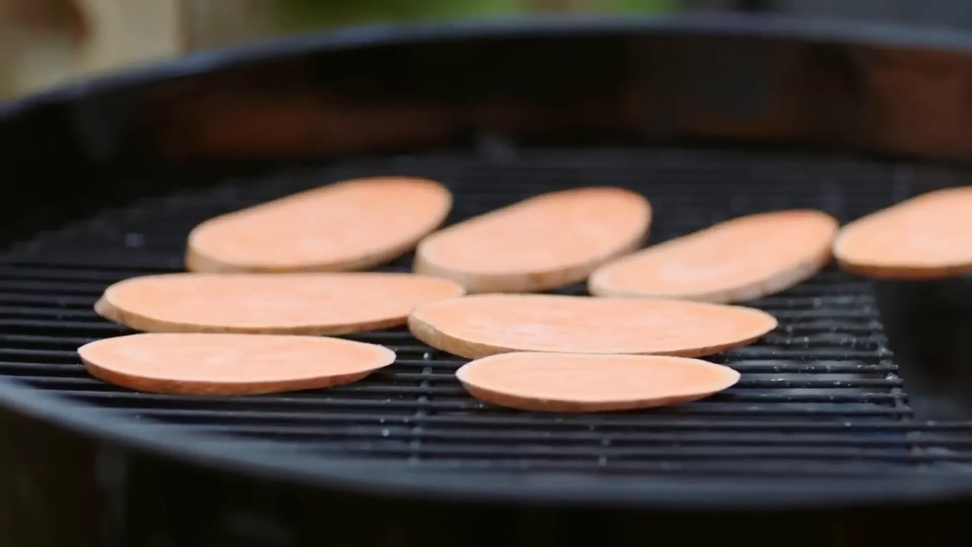Sweet potato slices laid on the barbecue grill
