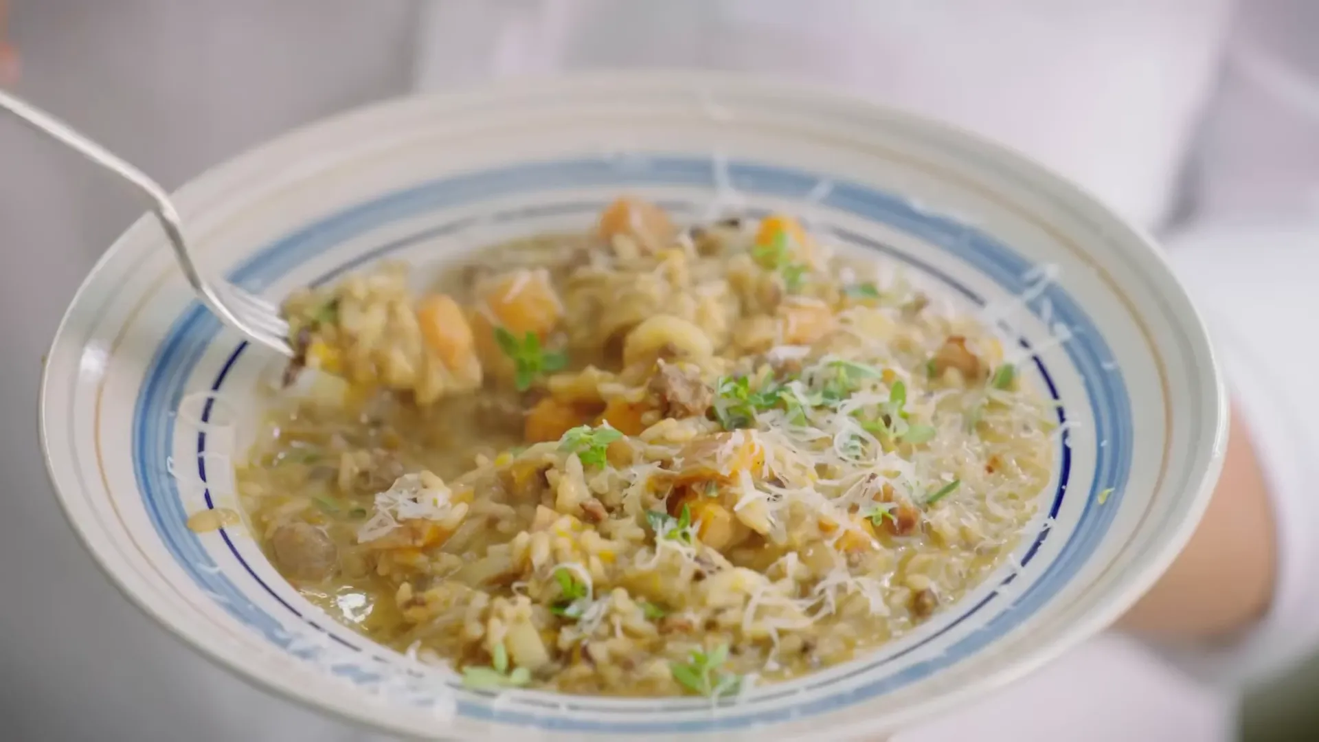 Creamy risotto being finished with parmesan and thyme