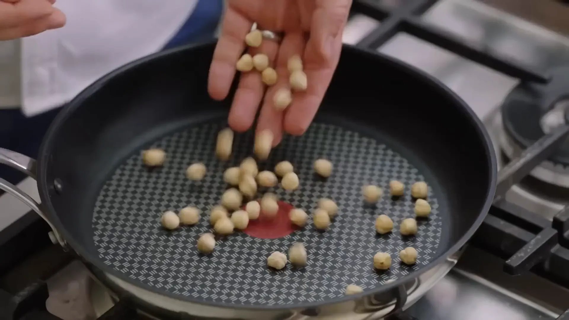 Hazelnuts toasting in a pan for added flavor and crunch