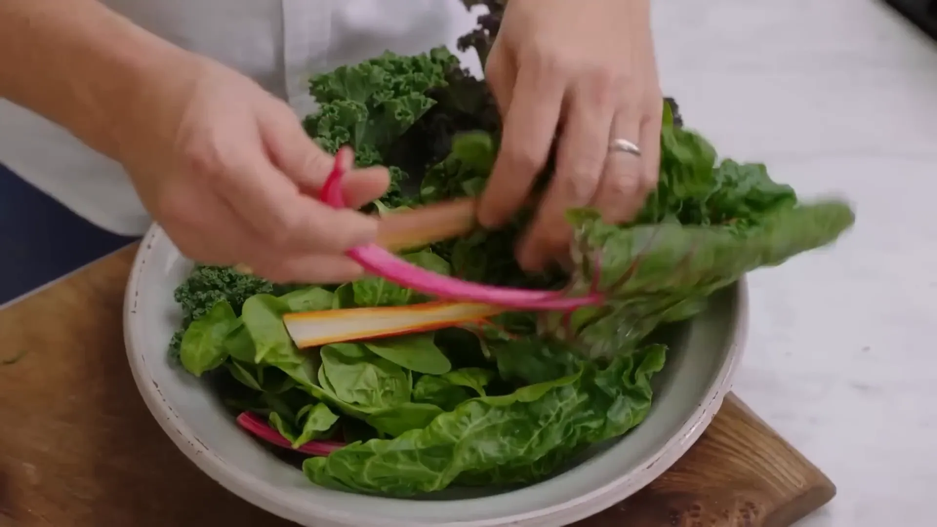 Fresh Swiss chard, kale, and spinach being prepared for blanching