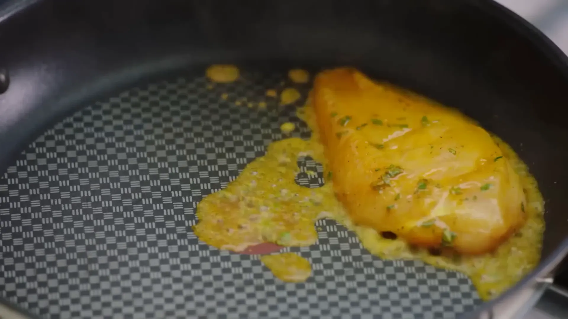 Chicken breasts searing in pan alongside roasted red peppers