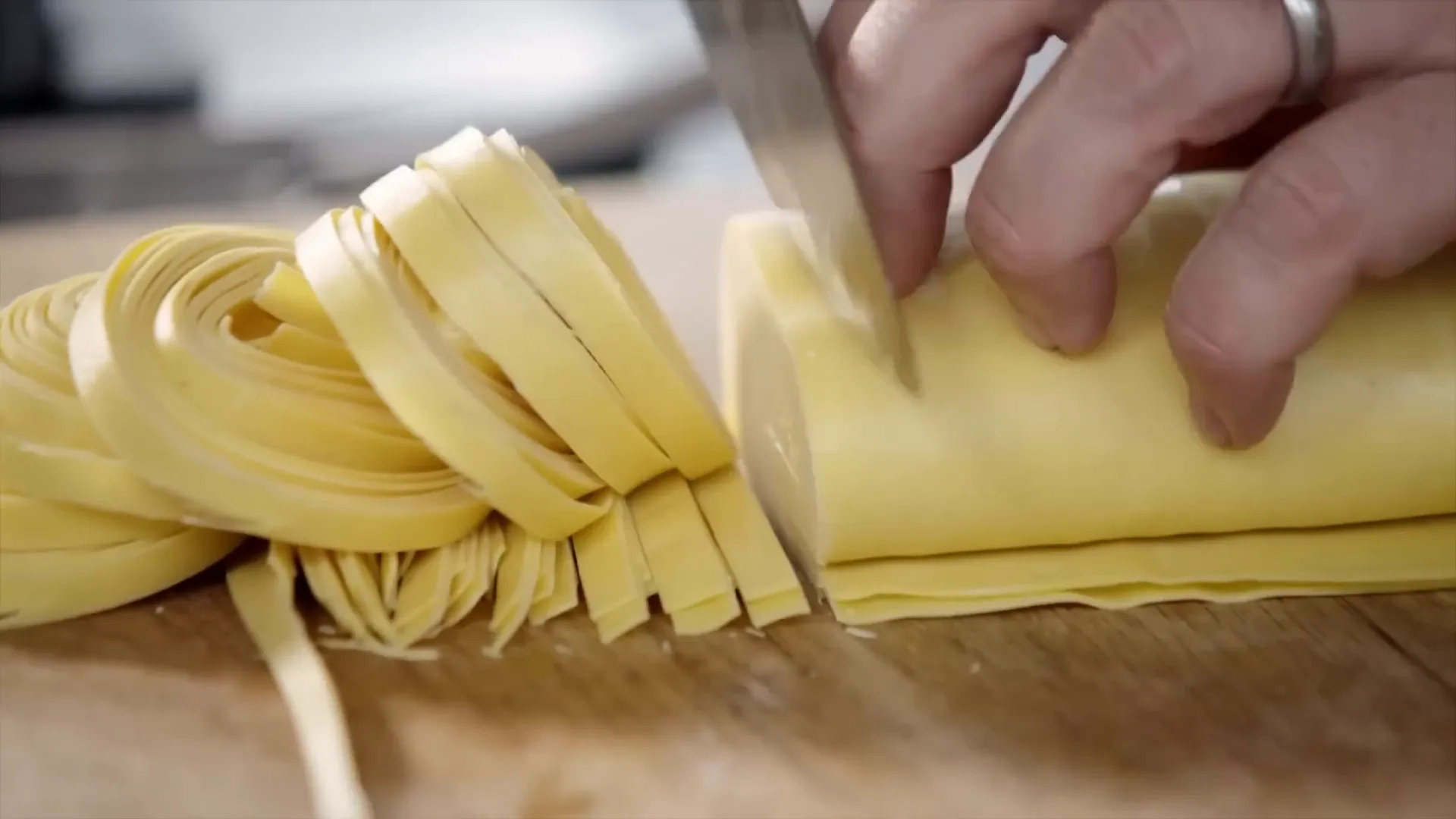 Cutting fresh lasagna sheets into pasta ribbons