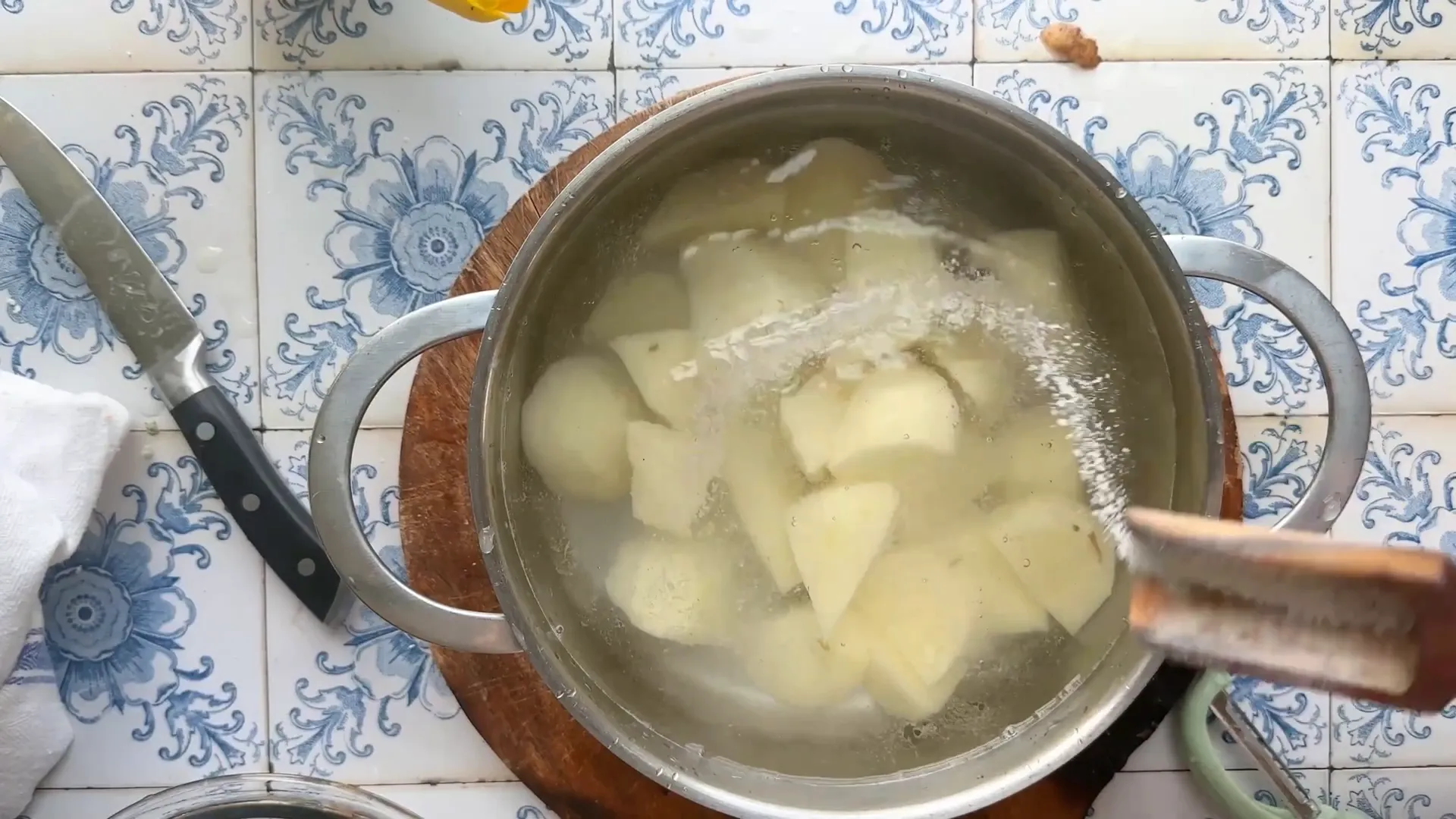Russet potatoes peeled and cut into large chunks in a bowl of cold water