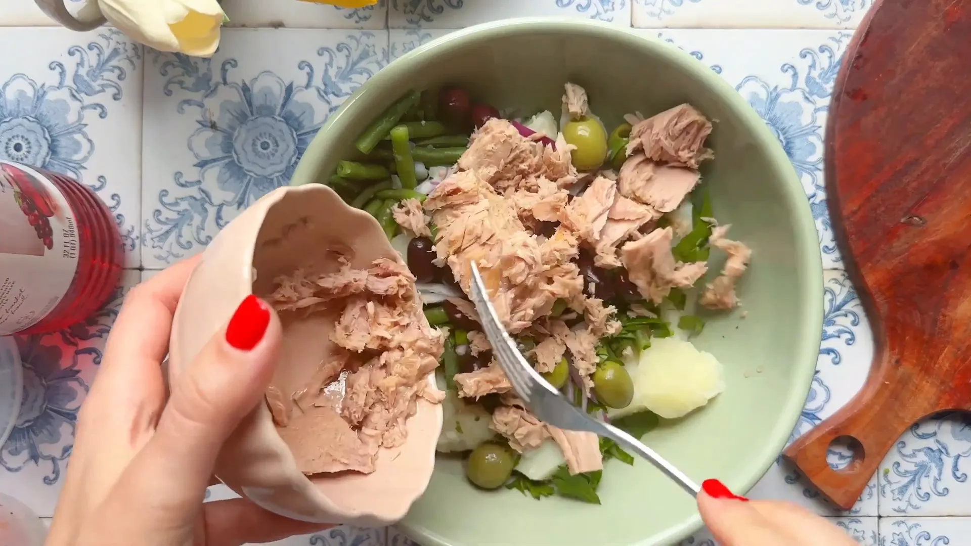 Adding tuna packed in olive oil to the salad ingredients