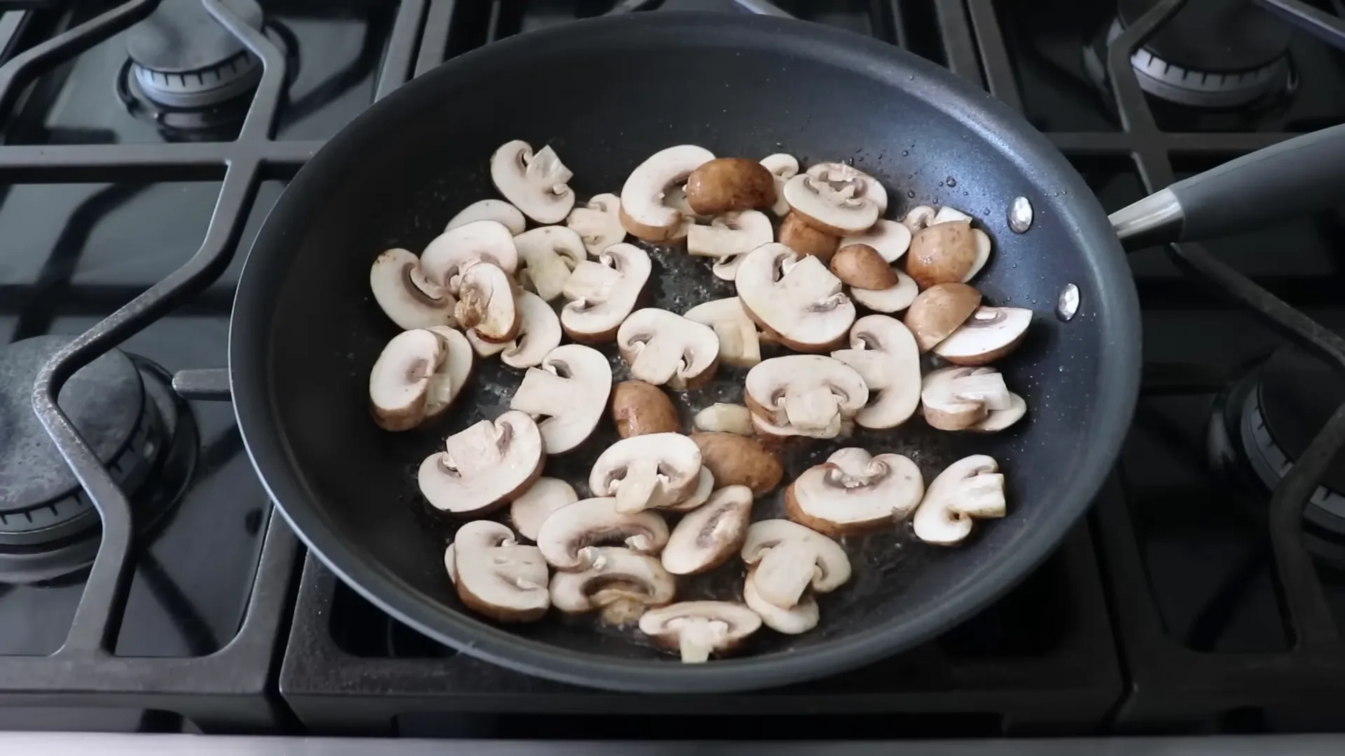 Sliced mushrooms sizzling and browning in the pan
