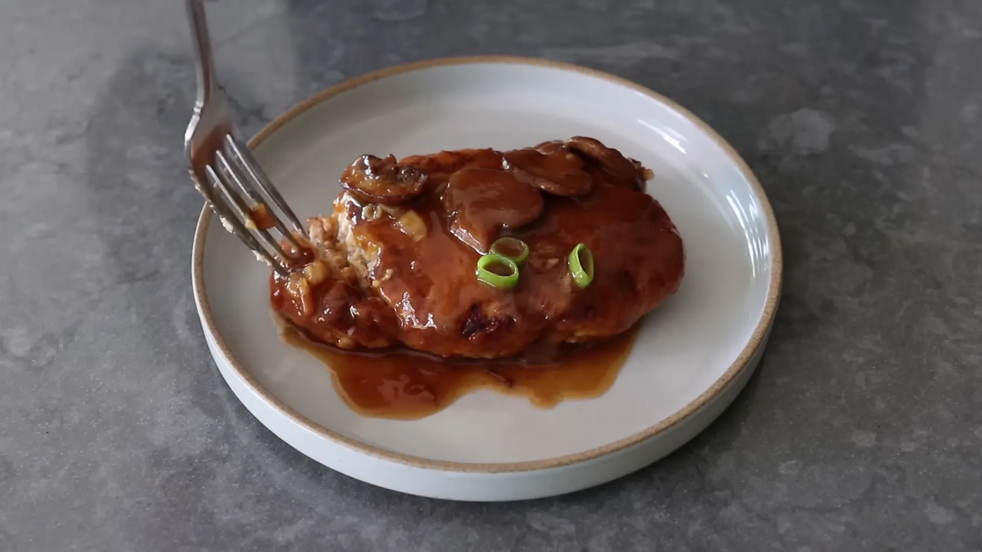 Plated chicken Salisbury steak with mushroom sauce served over mashed potatoes