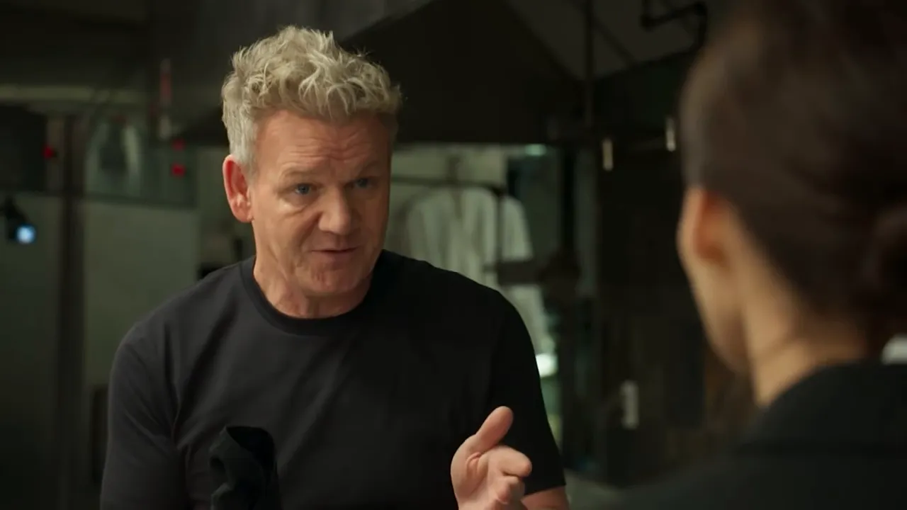 Lead chef speaking to staff in a busy restaurant kitchen