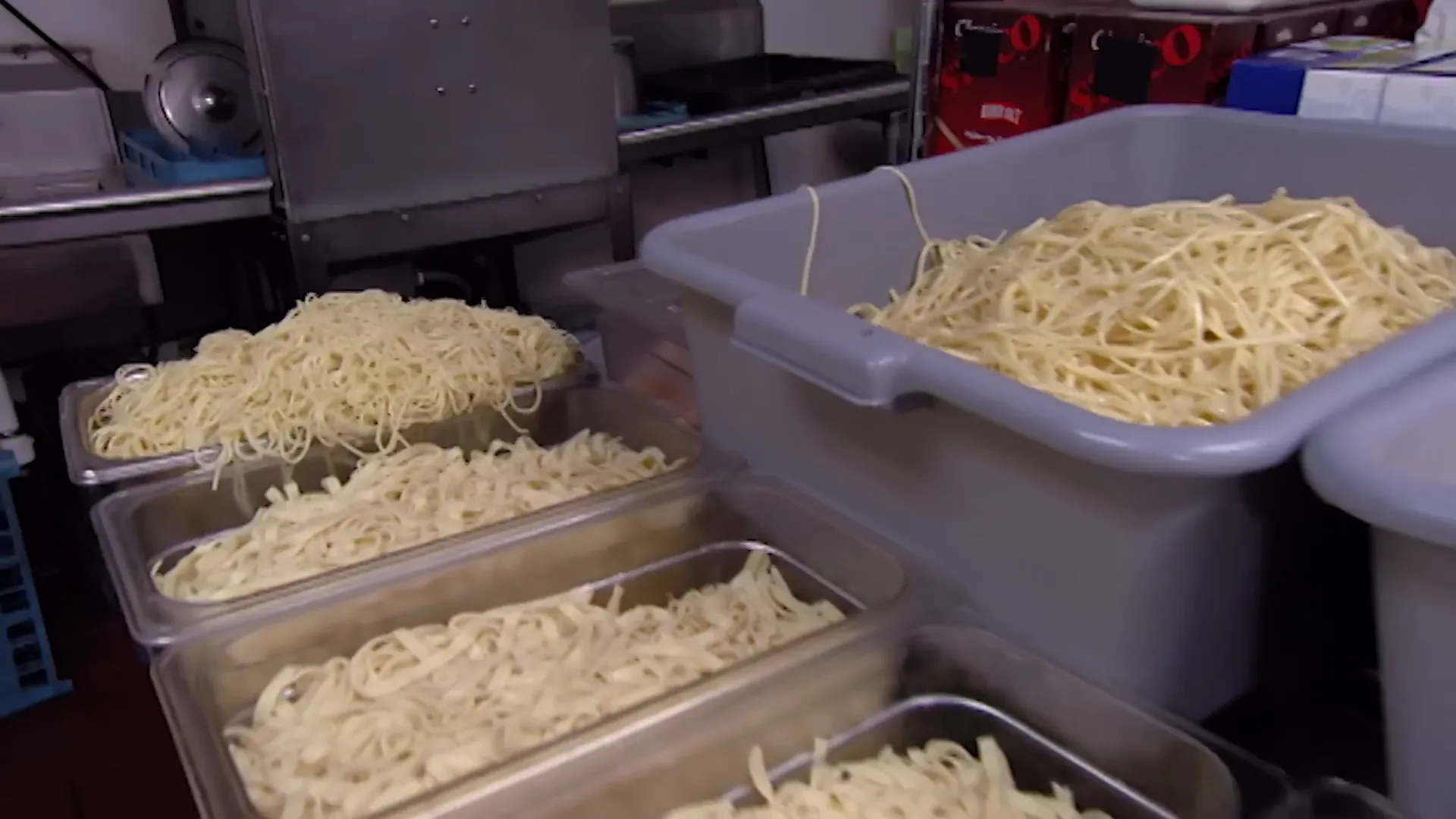 Piles of pre-cooked pasta containers stacked in the kitchen