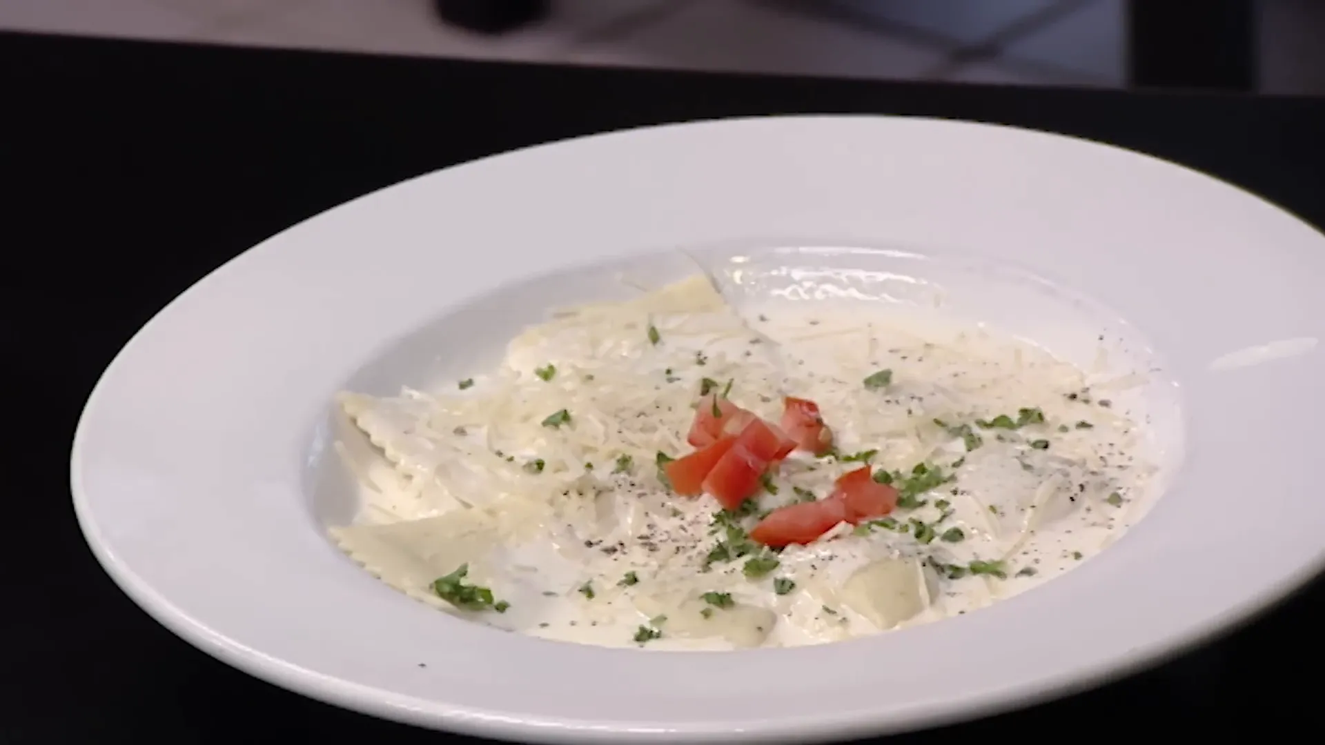 A plate of defrosted ravioli with a poor-looking Alfredo sauce