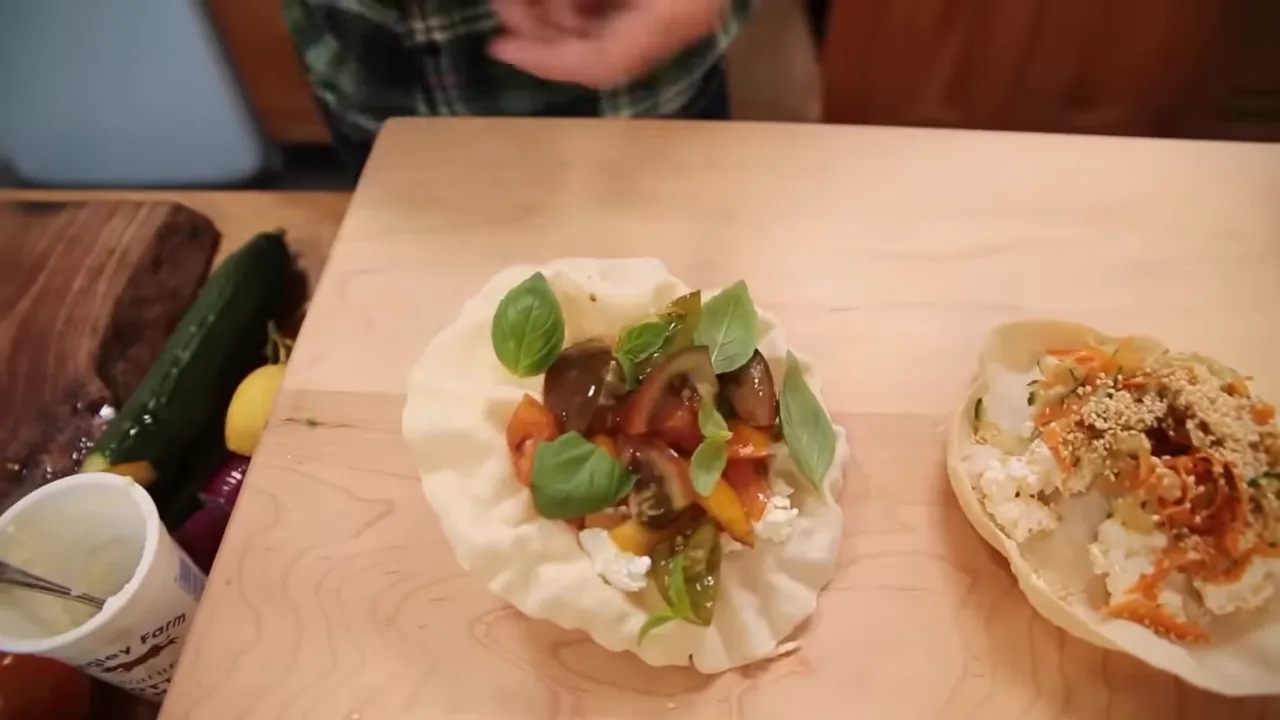 Close-up of a poppadom topped with chopped cherry tomatoes, torn basil leaves and a drizzle of balsamic
