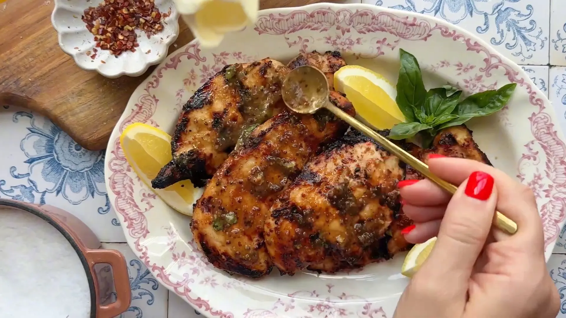 Brushing reserved marinade over hot grilled chicken