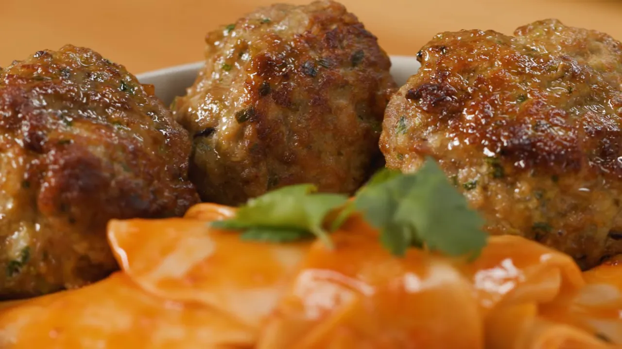 Close-up of dumpling meatball pasta with seared meatballs and glossy chili-miso sauce