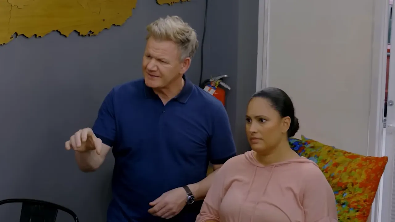 lead chef giving direction while an owner listens in the dining area