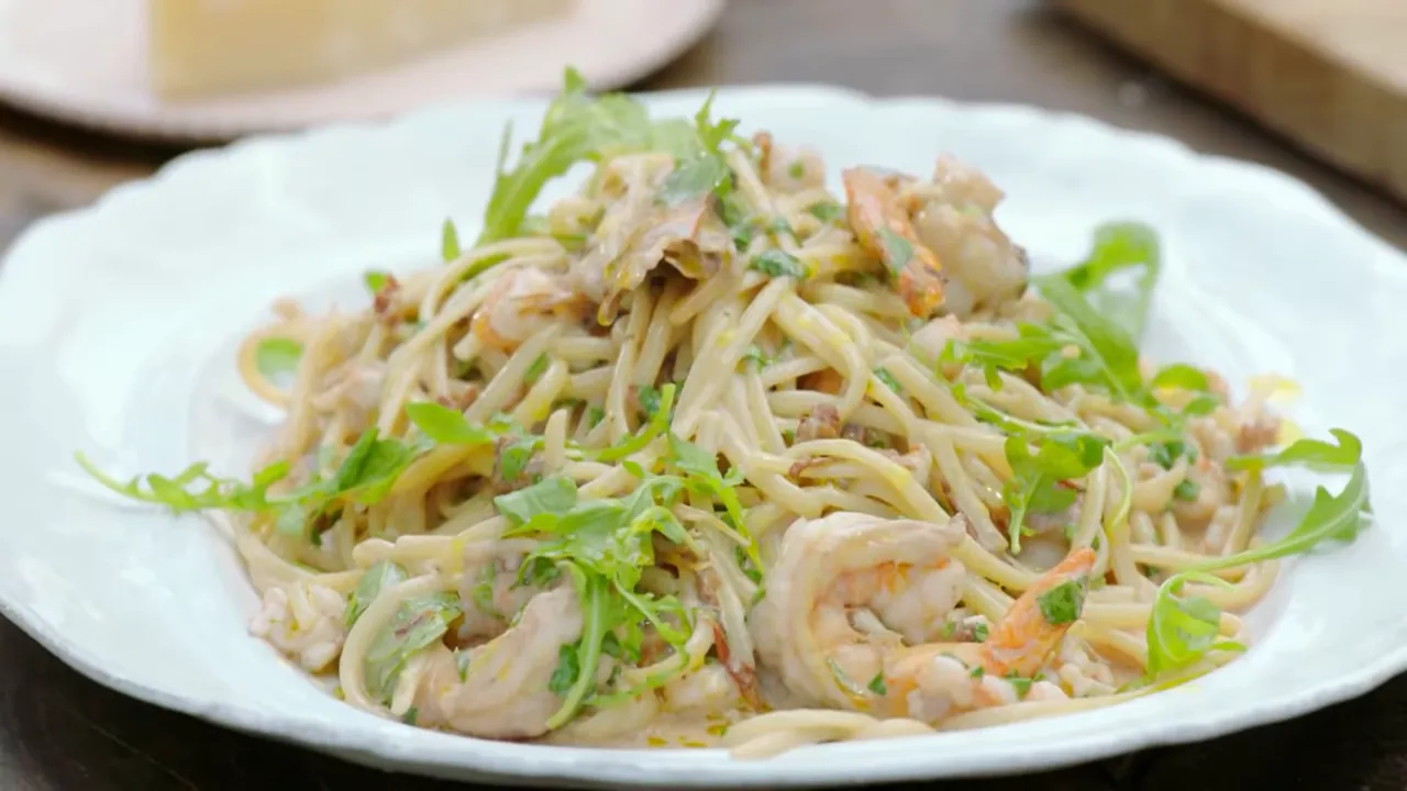 Close-up of prawn linguine with mascarpone, pancetta and rocket on a white plate