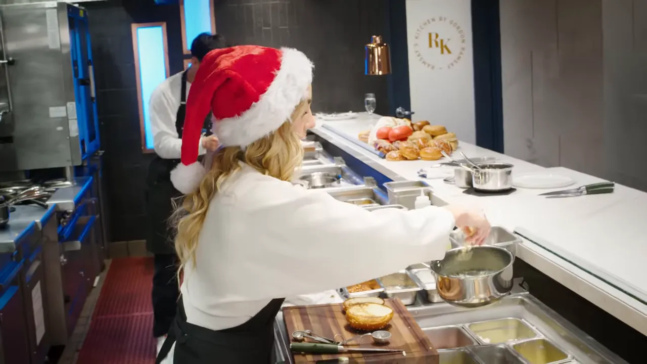 Chef spooning bechamel sauce over two toasted bread halves on a cutting board at a kitchen pass.