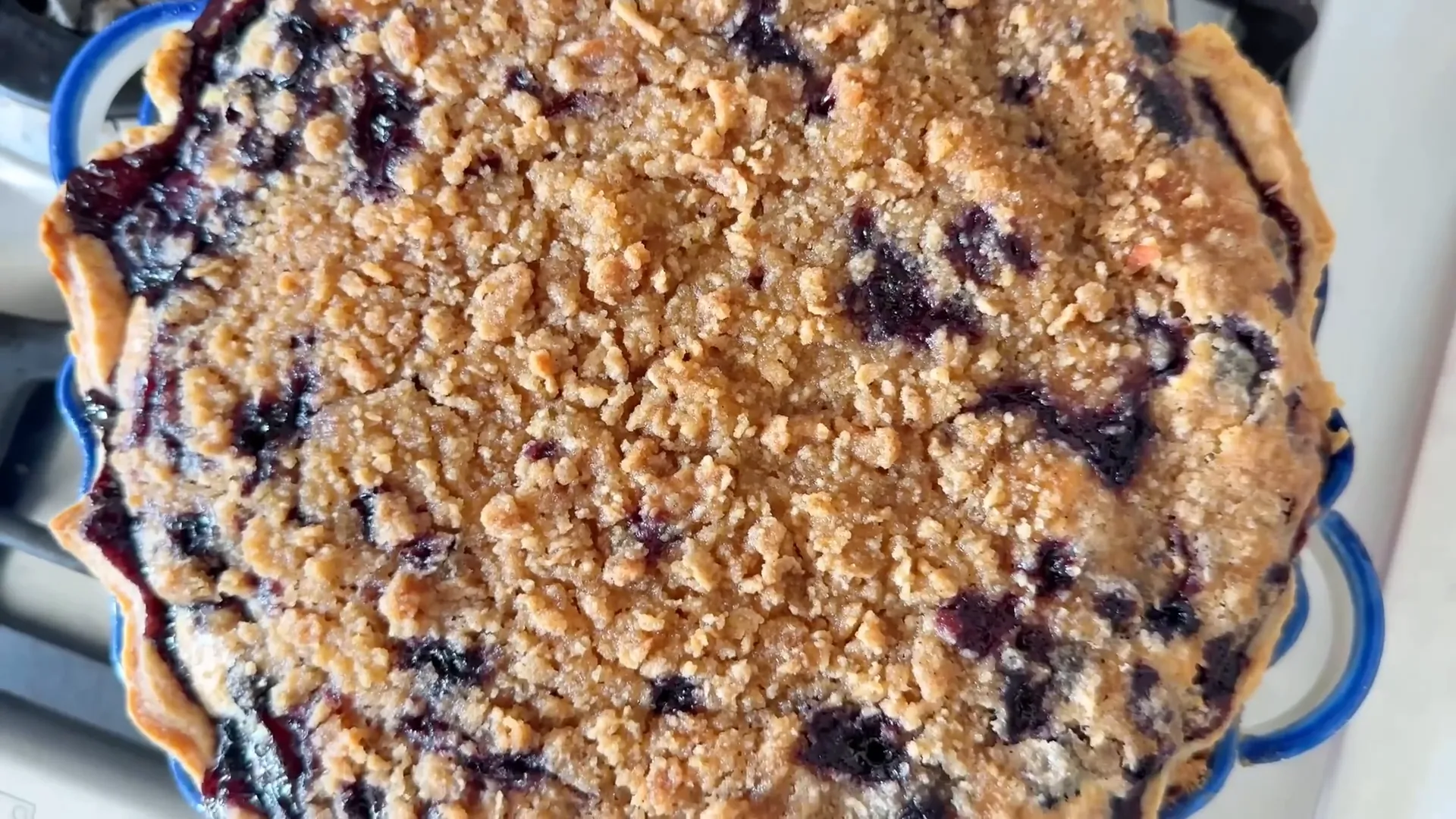 Golden crumble topping and bubbling blueberry custard pie fresh from the oven