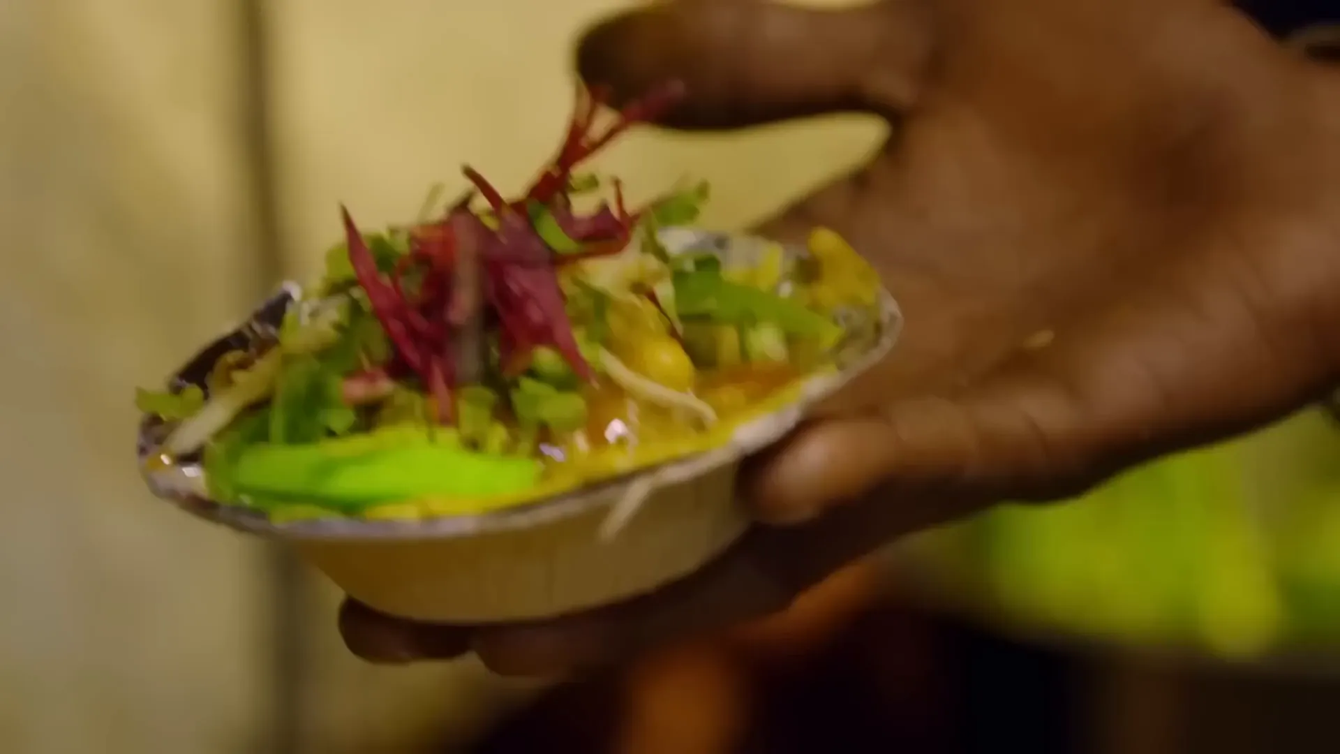 Chickpea curry topped with chutneys, pomegranate seeds, and fresh herbs