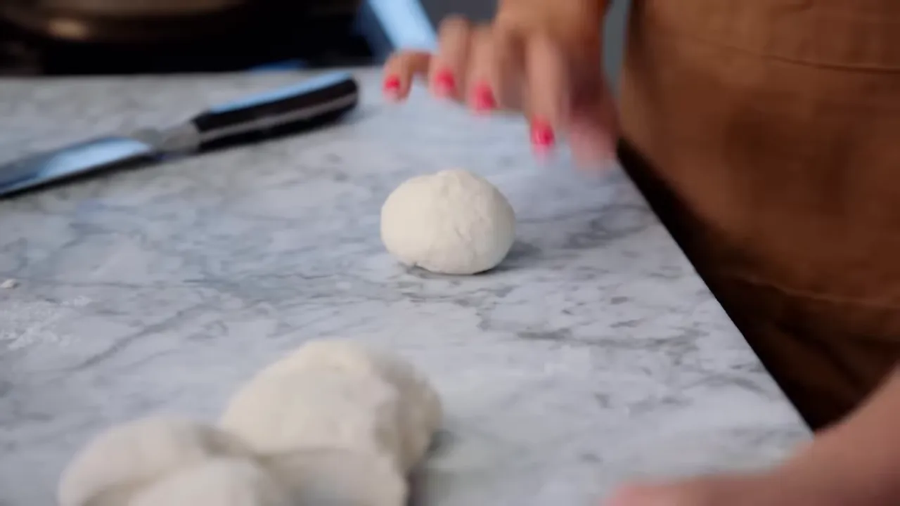 hands feeling the dough to check pliability