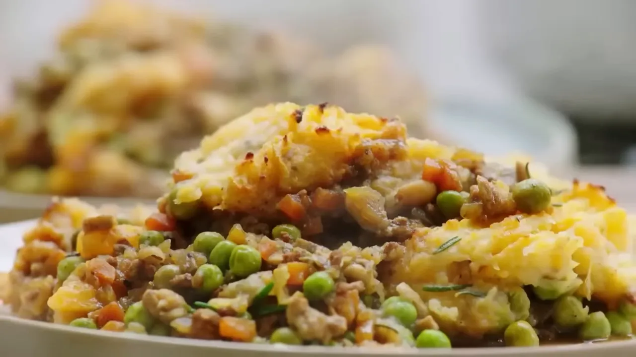 Plated shepherd's pie portion with peas and golden mashed potato topping
