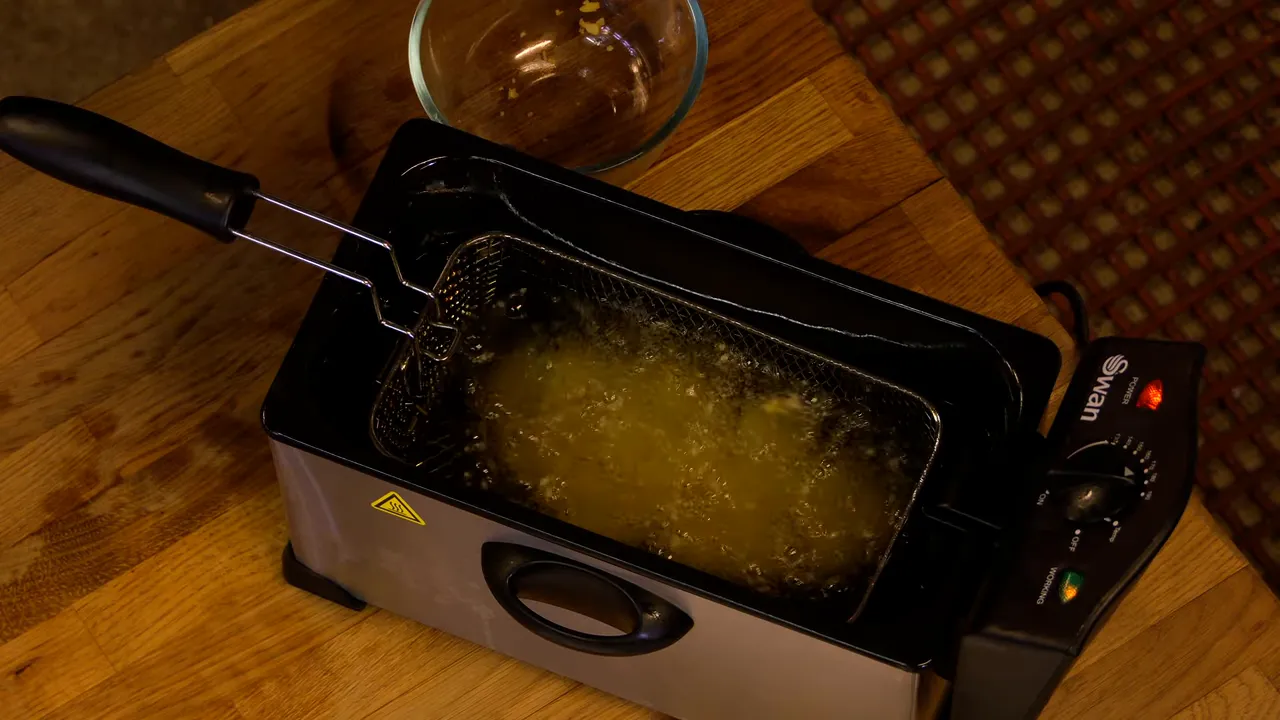 Deep fryer with tater tots frying in bubbling oil