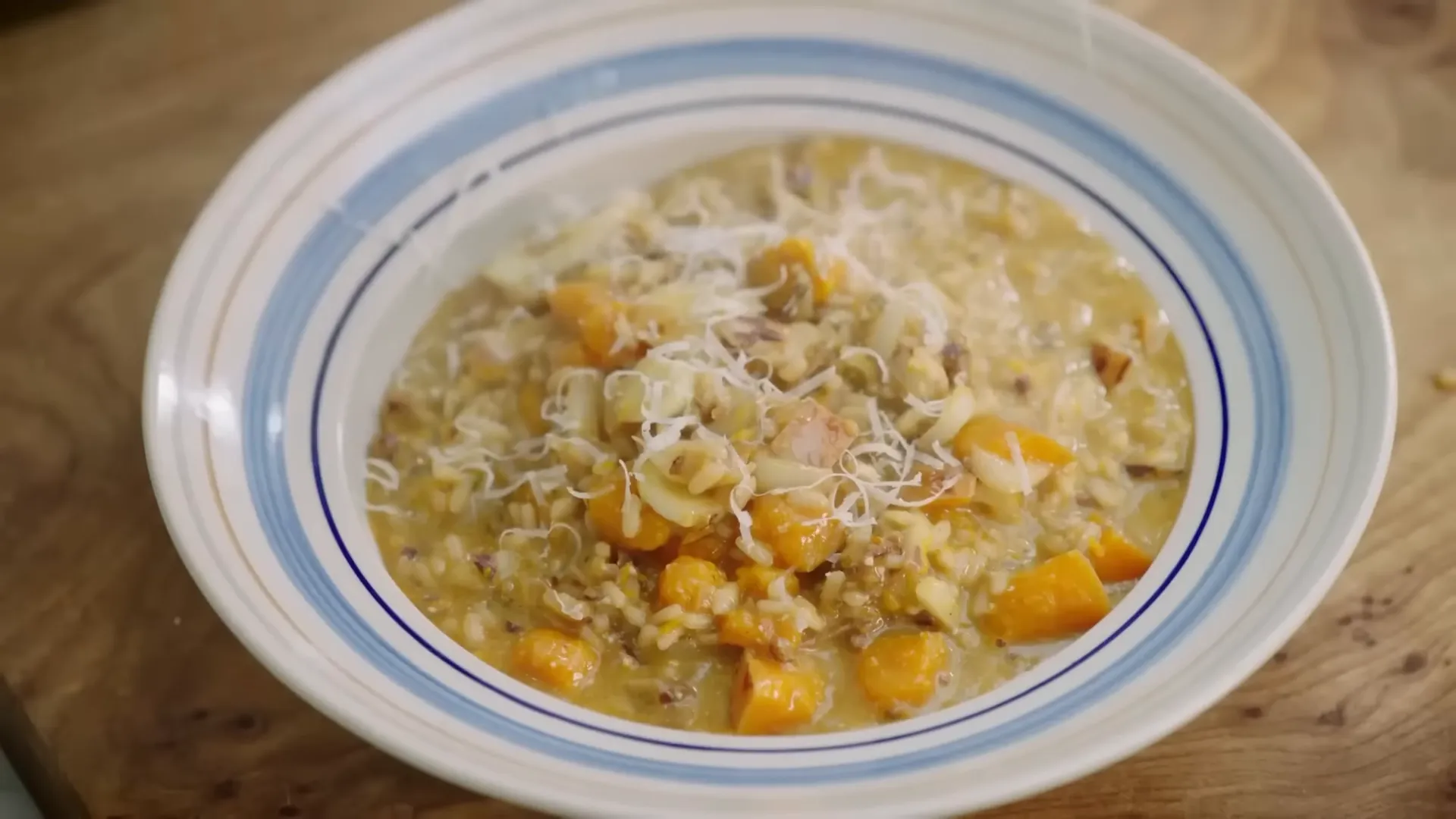 Finished creamy risotto in a warm bowl with thyme and grated parmesan