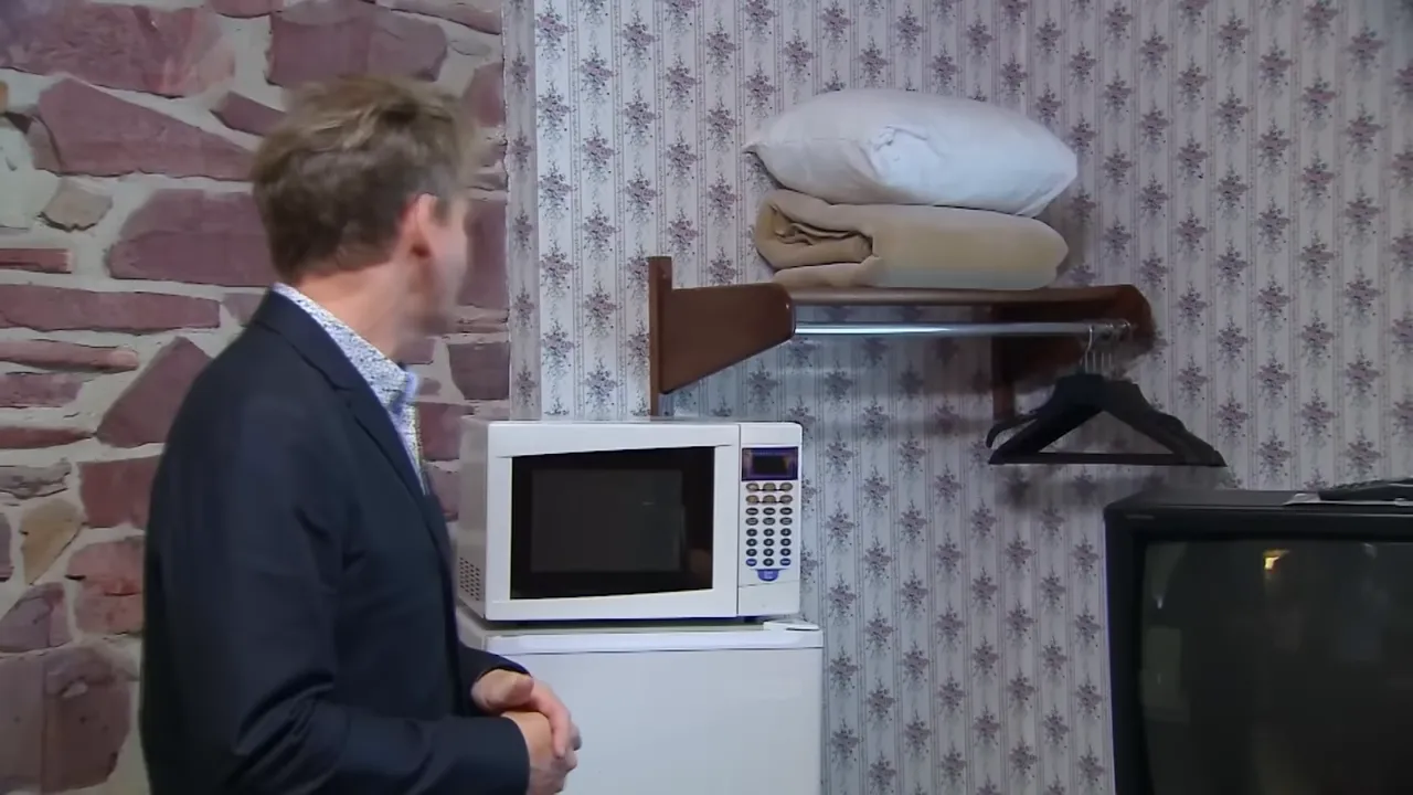 Guest room corner showing mold and worn wallpaper