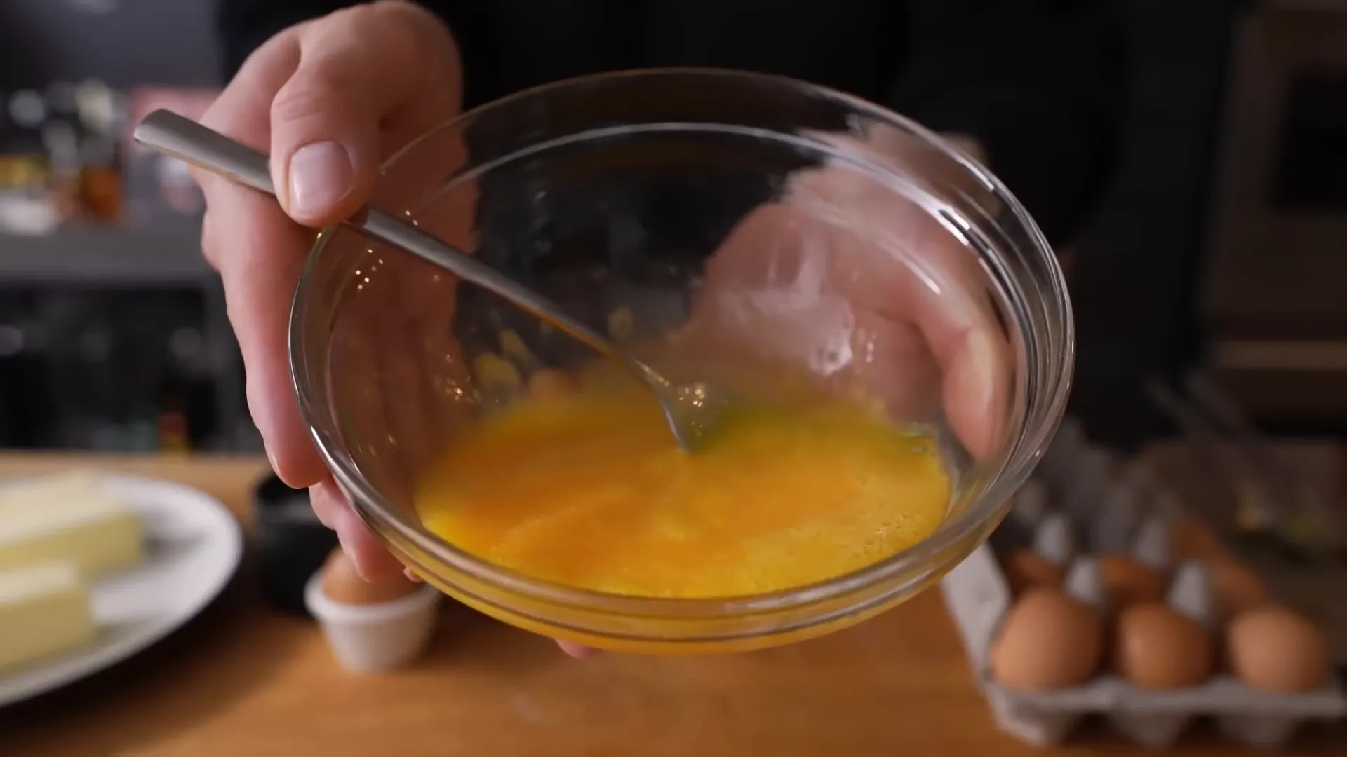Beaten eggs resting in bowl after salt was added, slightly paler