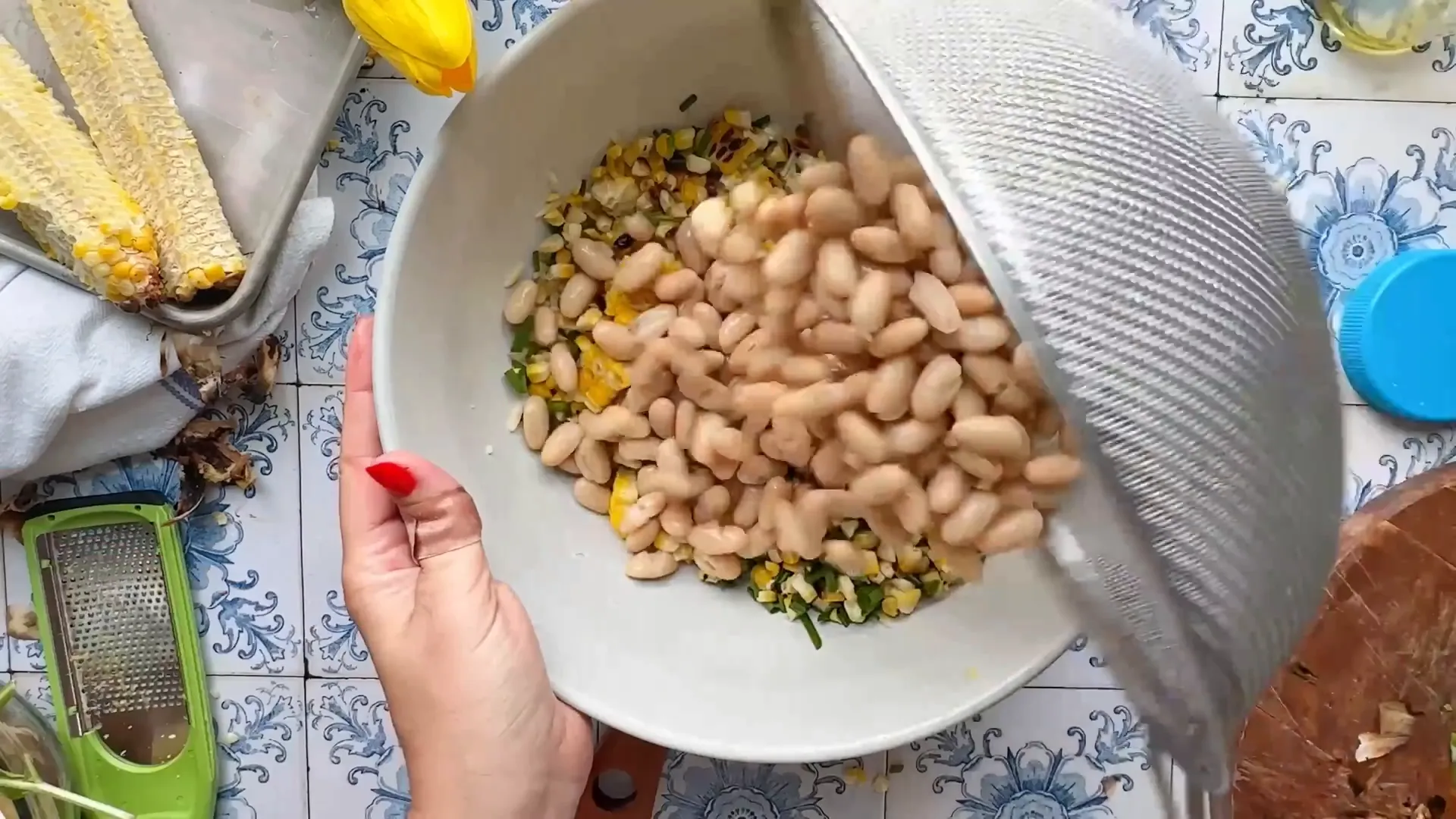 Adding orzo, corn, chives, and cannellini beans to a large bowl