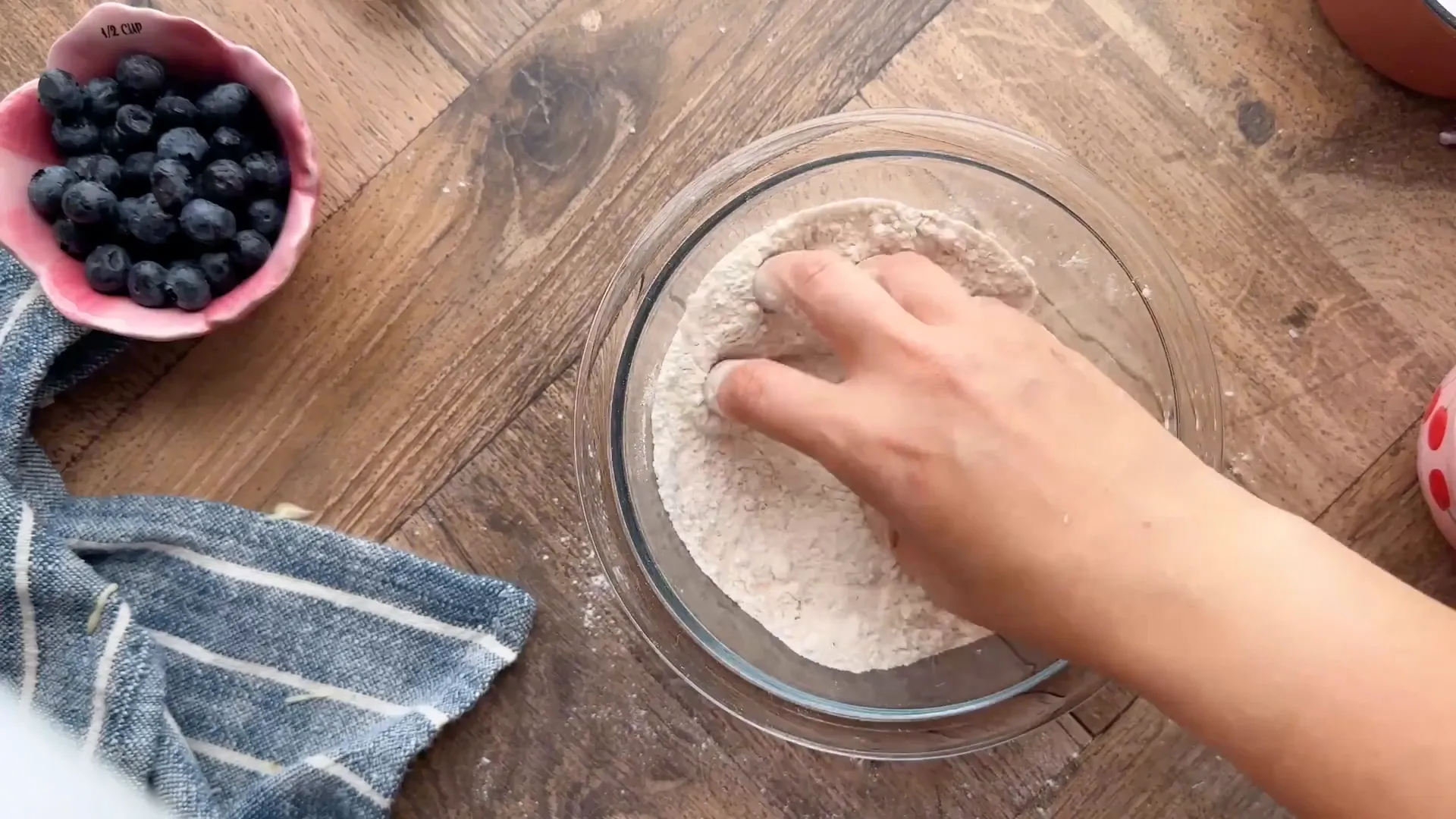 Crumb topping being mixed and sprinkled over muffins