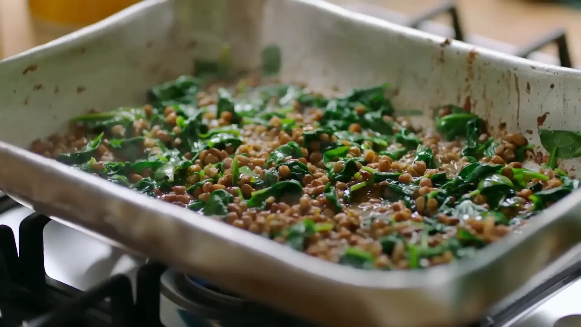 Lentils being seasoned and finished with crème fraîche