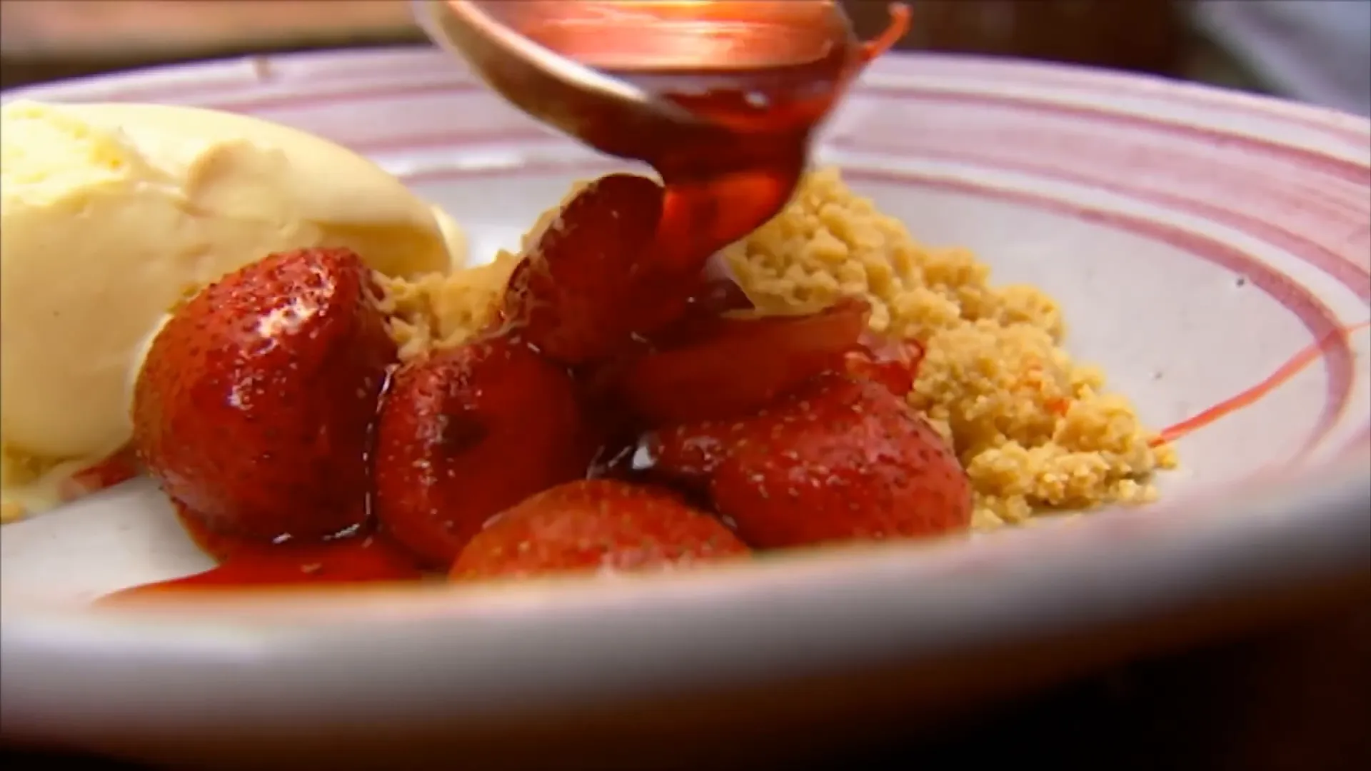 Grilled strawberries bubbling with vanilla syrup topped with ice cream