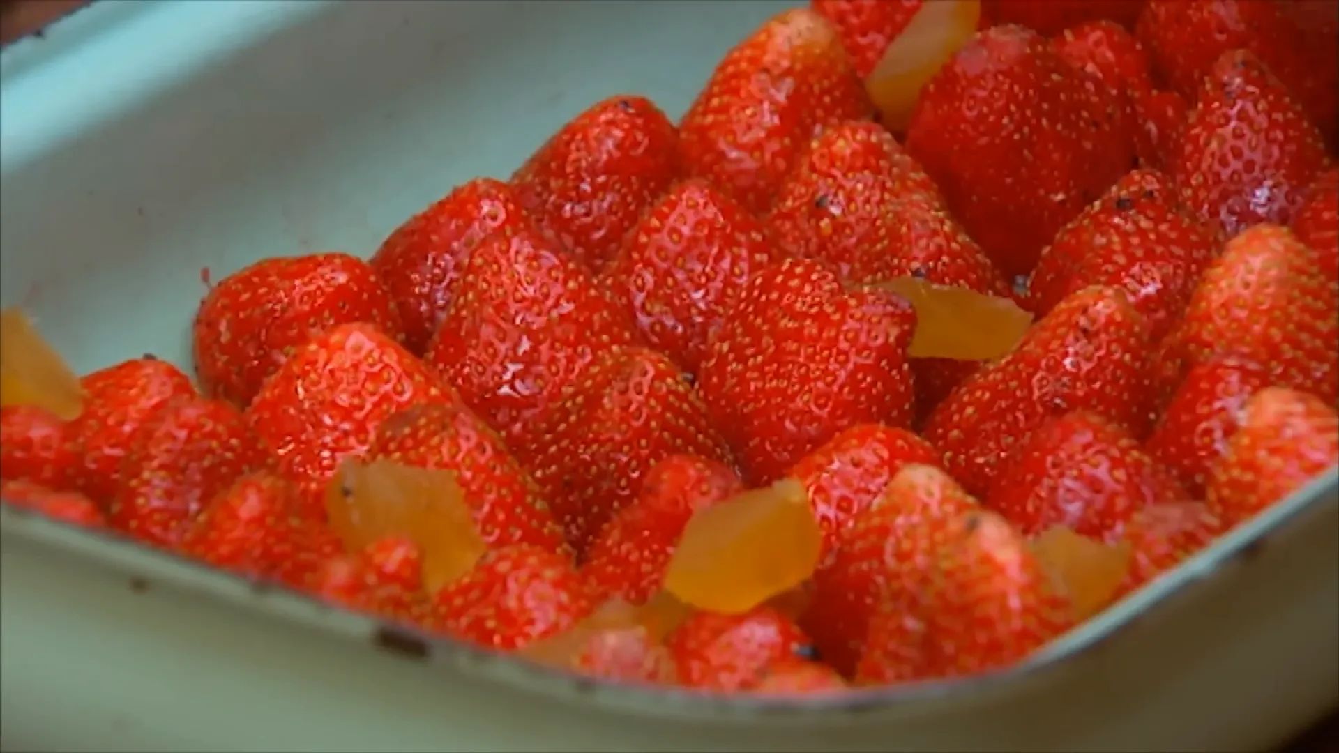 Candied ginger pieces sprinkled between strawberries