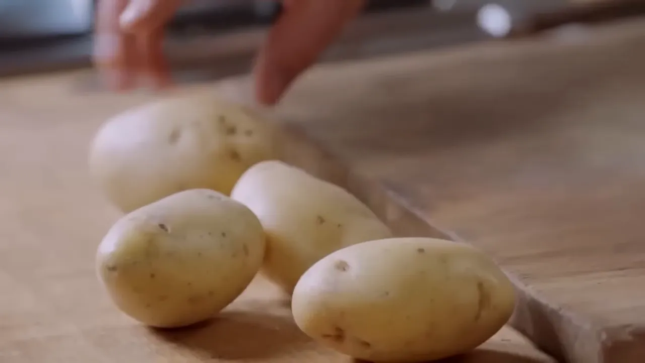 small new potatoes on a wooden chopping board ready for preparation