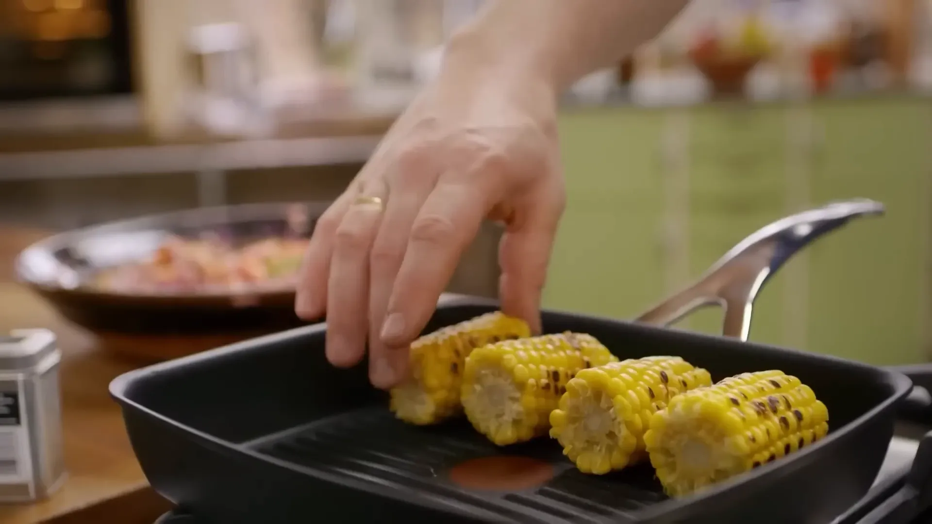 Charred corn on the cob cooking on a griddle