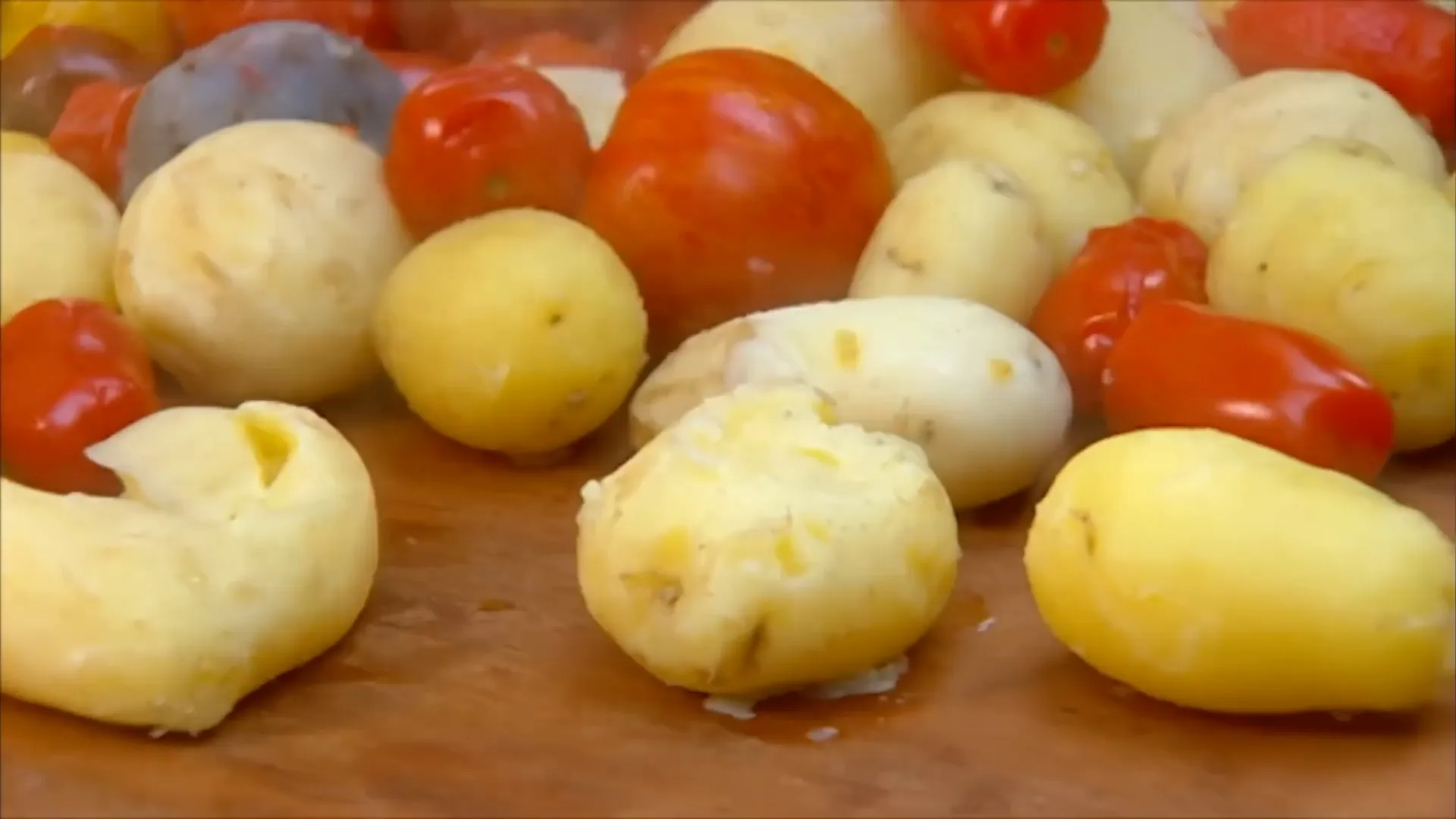 Crushed new potatoes laid out on a board ready for seasoning