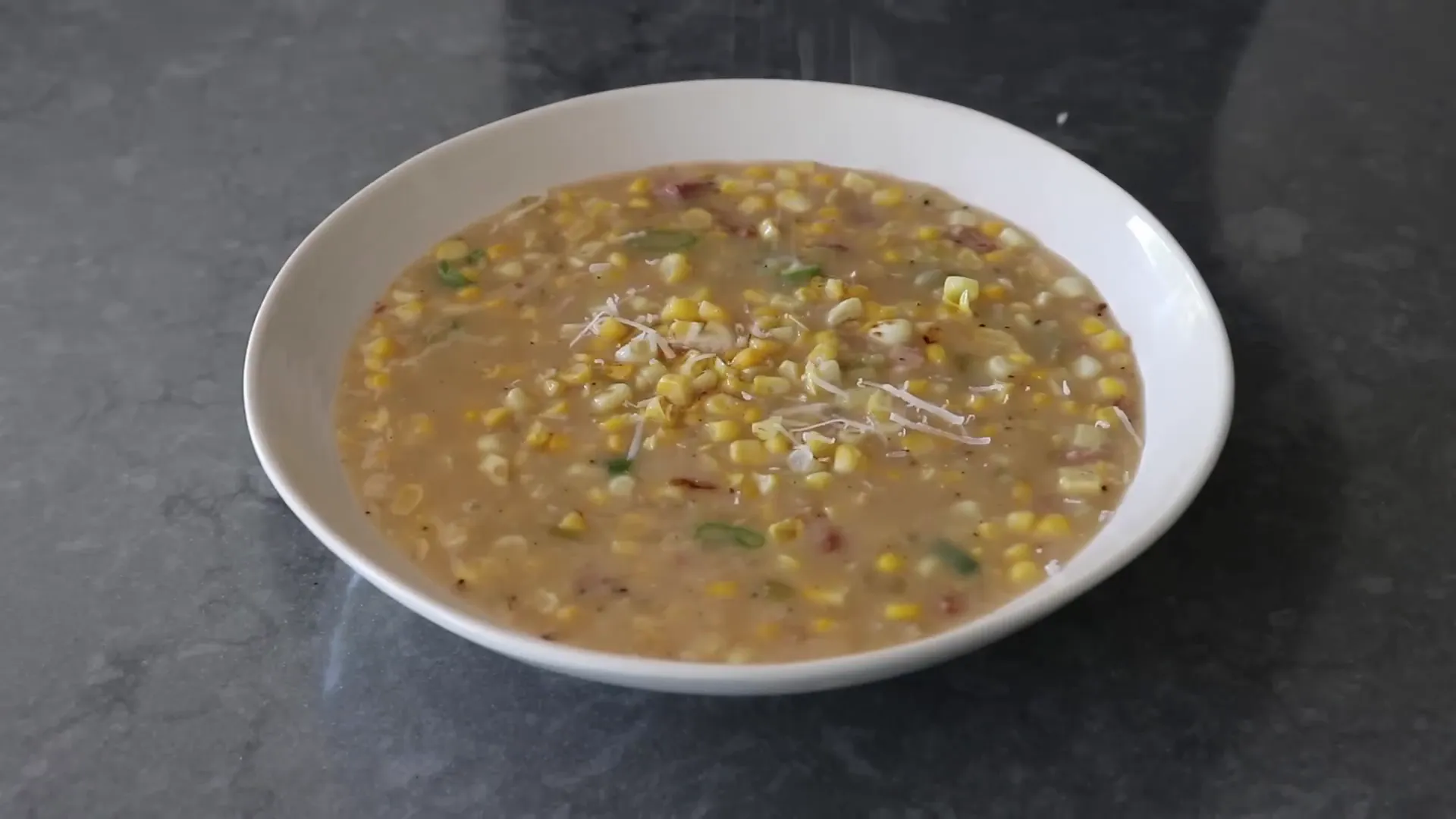 Finished chowder topped with cheese, pancetta, green onions and black pepper