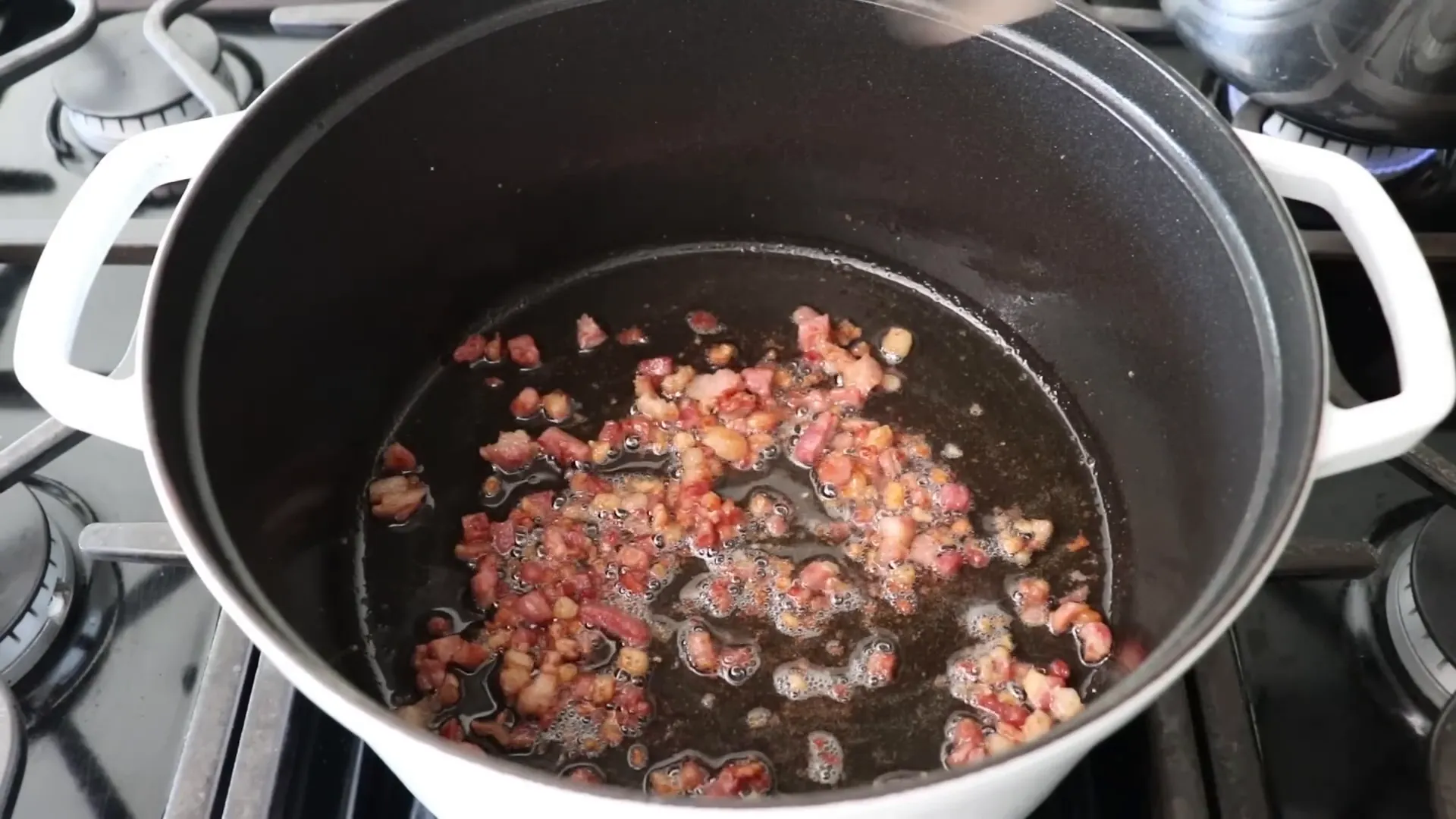 Pancetta rendering in the pan until just crispy