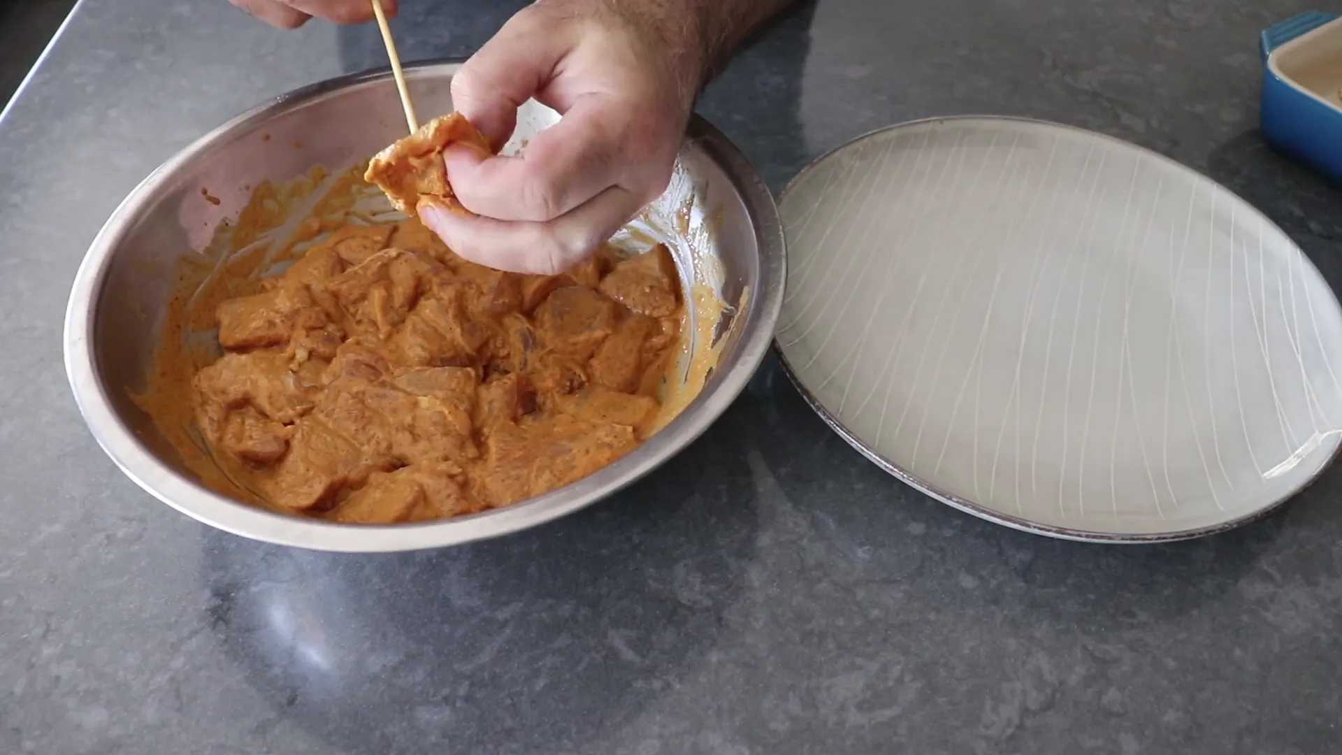 Skewering marinated chicken chunks on bamboo sticks