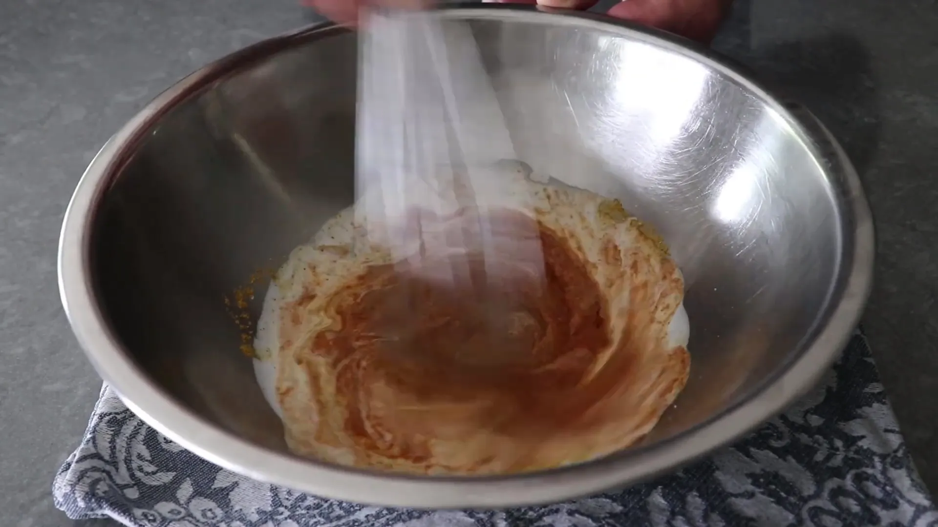 Mixing marinade ingredients including red curry paste and coconut milk