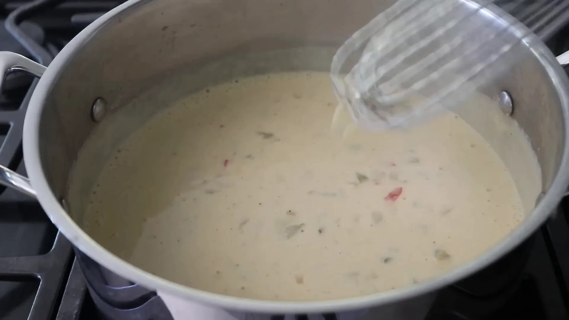 Whisking a roux as cream is added