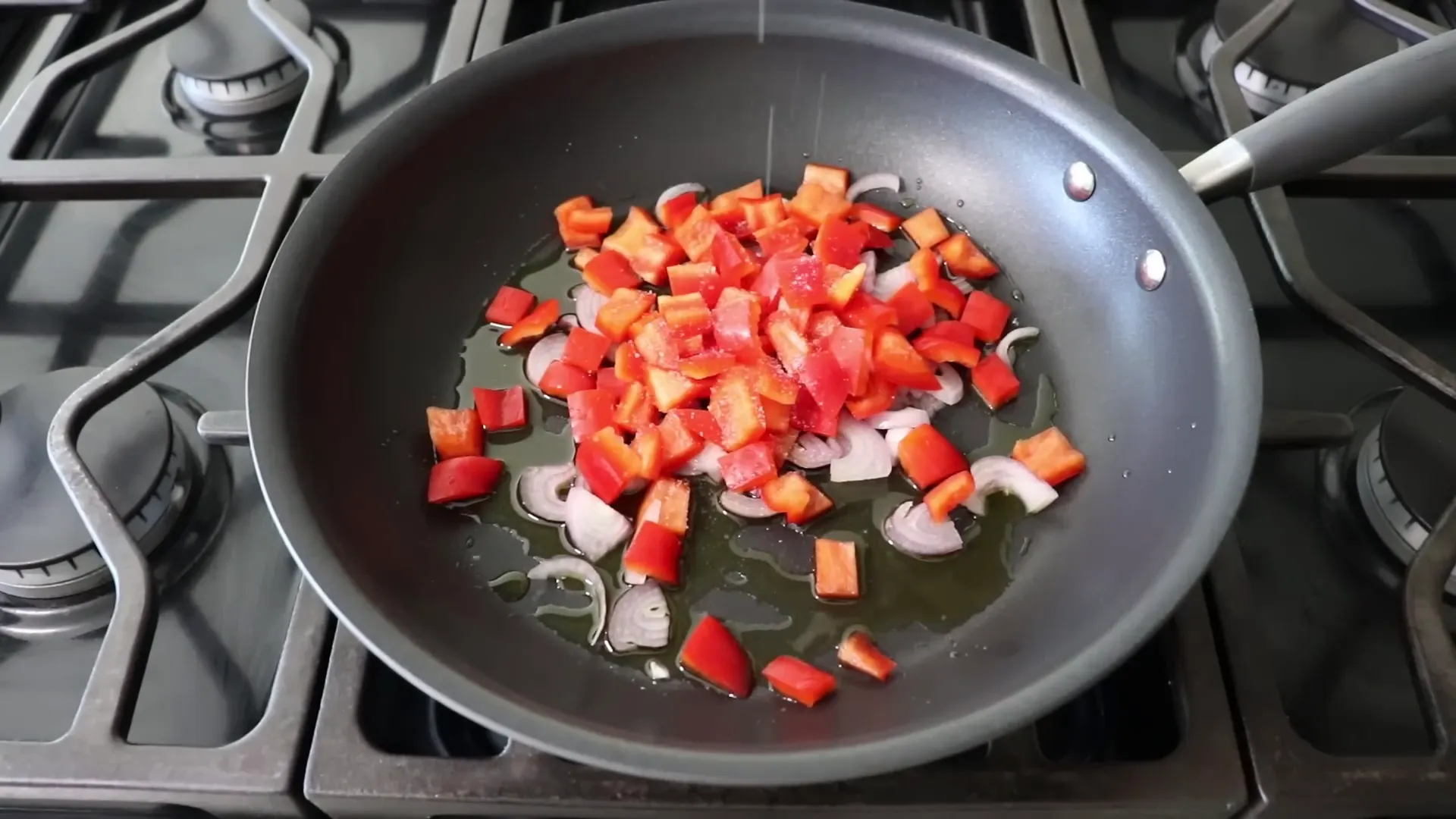 Sautéing shallots and bell peppers in olive oil