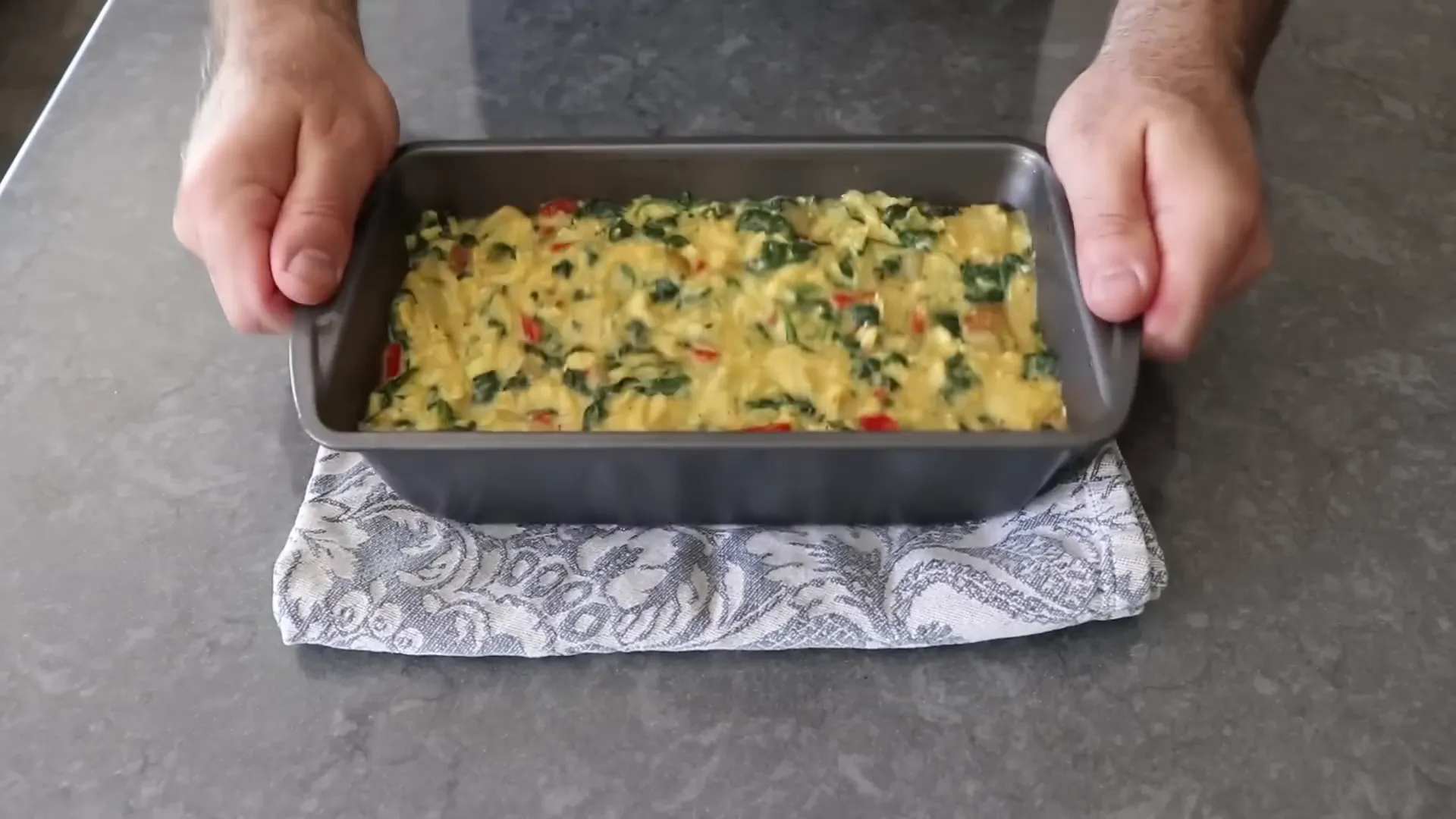 Frittata mixture settled in a parchment-lined loaf pan
