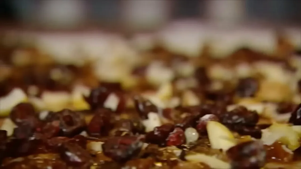 close-up of sour cranberries and chopped nuts scattered over mincemeat on pastry
